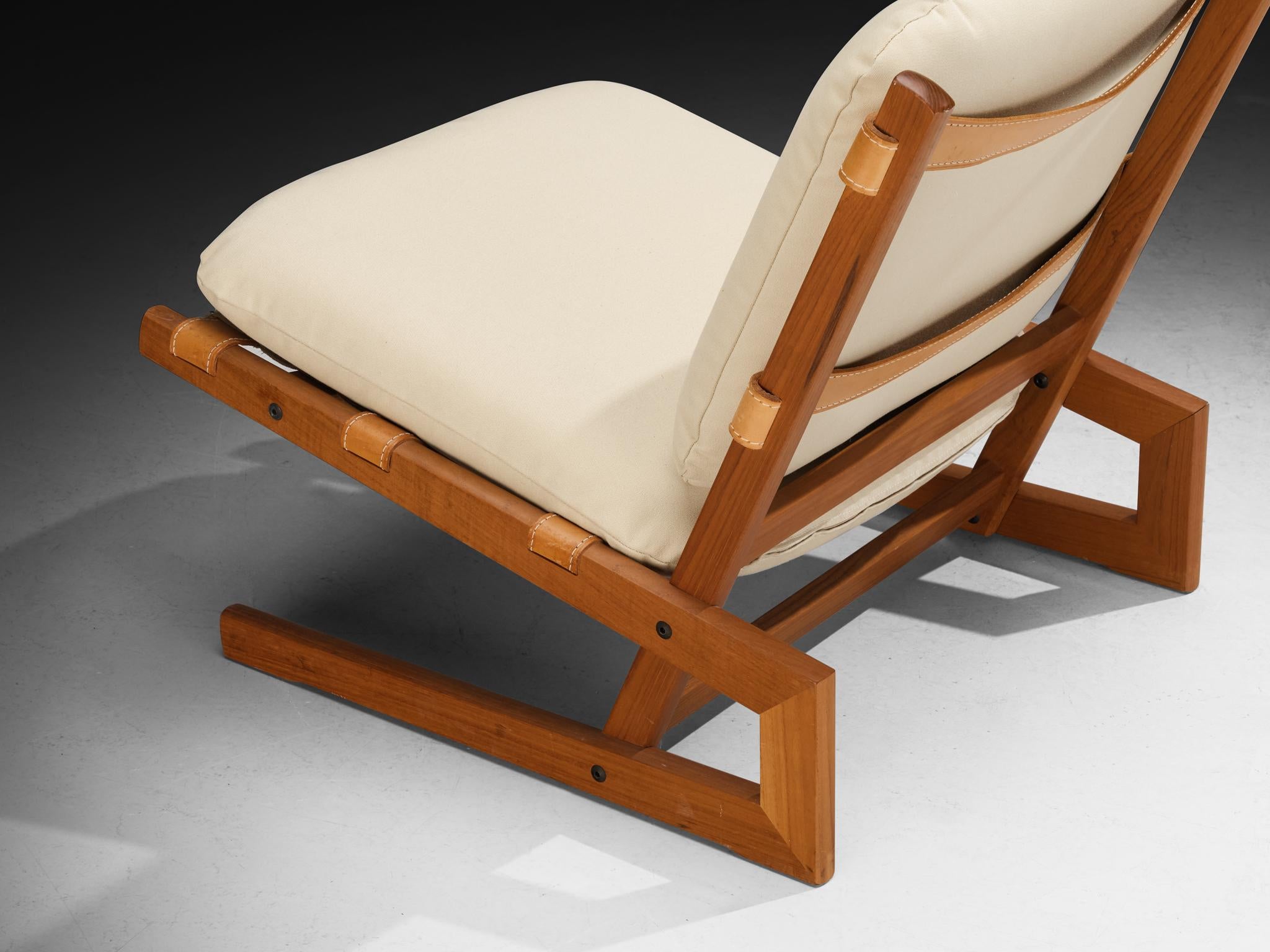 Sedia lounge Fabrice, teak, pelle, tessuto di tela, Scandinavia, anni '70 

Questa poltrona lounge a pantofola proviene dalla Scandinavia degli anni Settanta. La forma complessiva si presenta come un assemblaggio sicuro di angoli semplici: le gambe