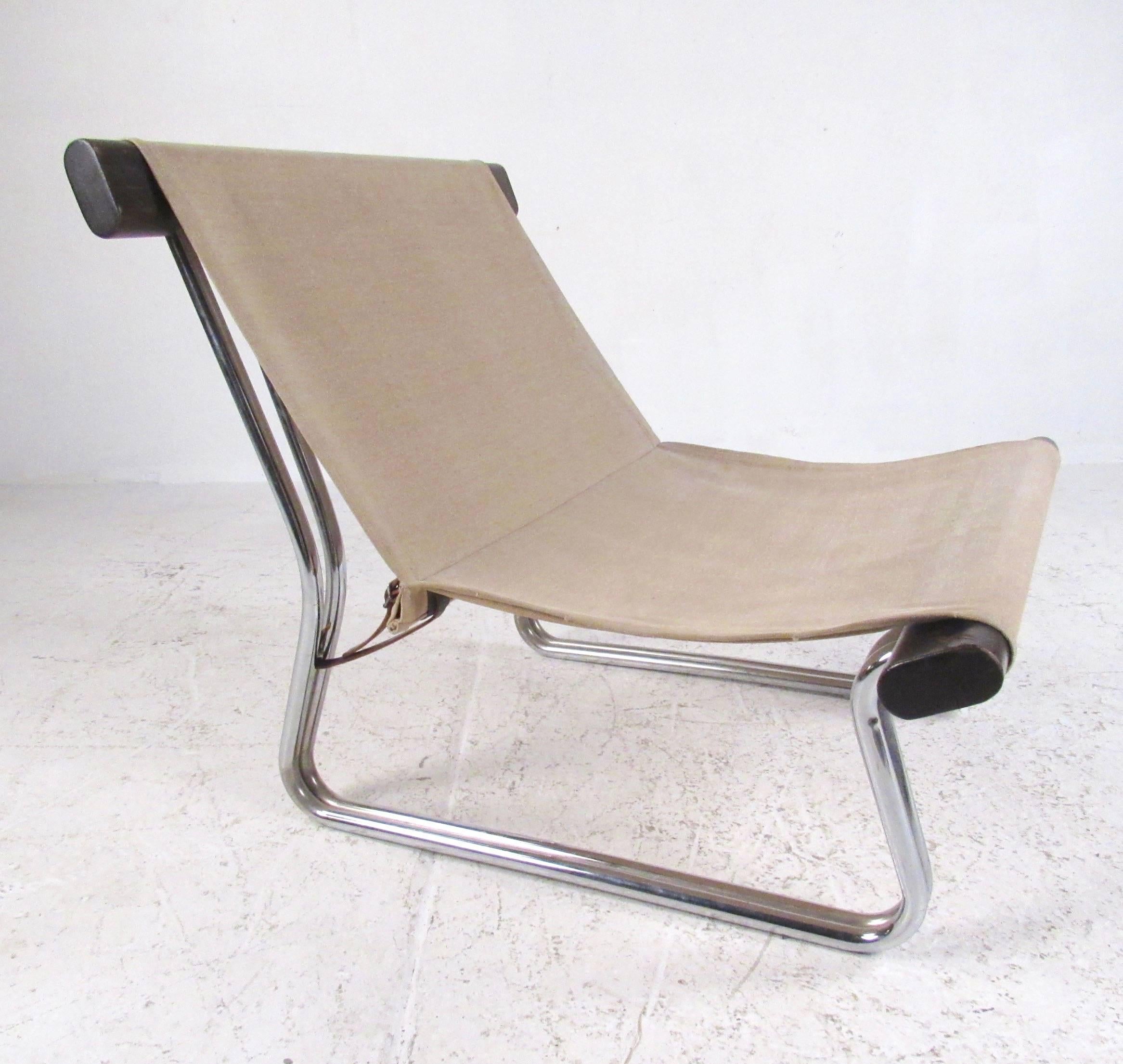 This vintage modern sling chair features tubular chrome and wood frame with a canvas seat. The Scandinavian modern slipper chair makes a striking yet simple midcentury addition to any seating area. Please confirm item location (NY or NJ).