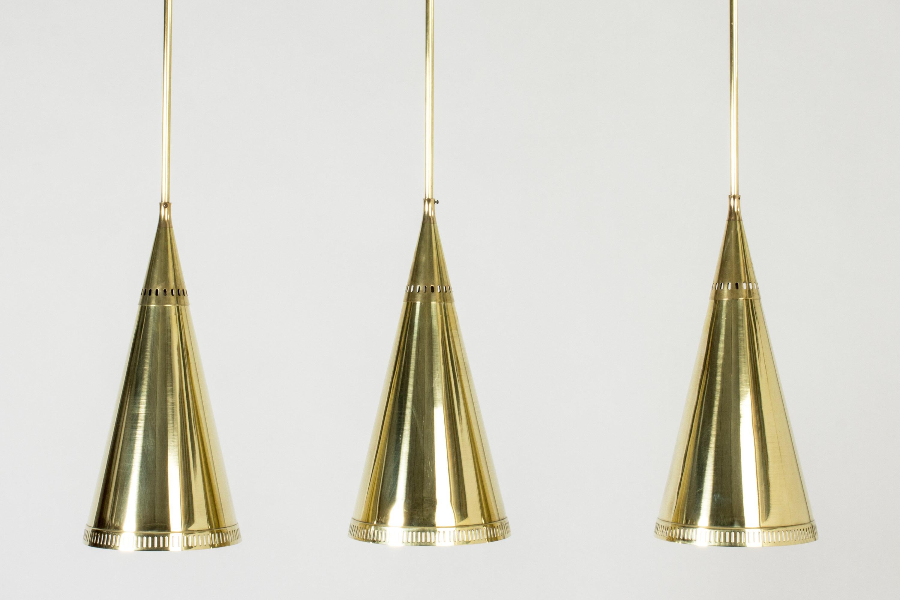 Set of three elegant brass ceiling lamps by Birger Dahl, with long brass stems. Conical shades with a perforated pattern around the rims.

The stems can be shortened.