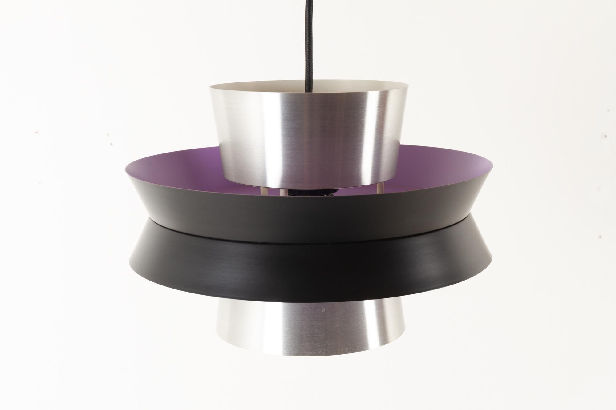 Scandinavian Modern ceiling pendant by Carl Thore for Granhaga Metallindustri , Sweden in the 1960s.

Ceiling lamp with multiple shades in aluminum. Outside in black and silver. Inside in purple and white. Very beautiful Scandinavian Modern lamp,
