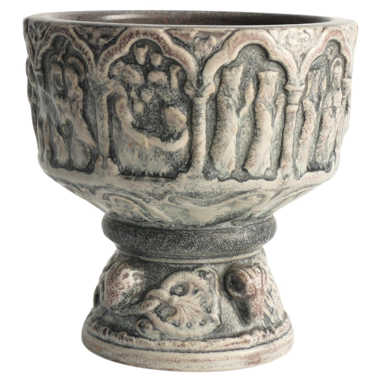 Cette coupe ou jardinière, fabriquée par Michael Andersen & Son, est une remarquable reproduction des fonts baptismaux découverts dans une église à Åkirkeby sur Bornholm. La police originale, ornée de couleurs bleues, a servi d'a.muse pour cette