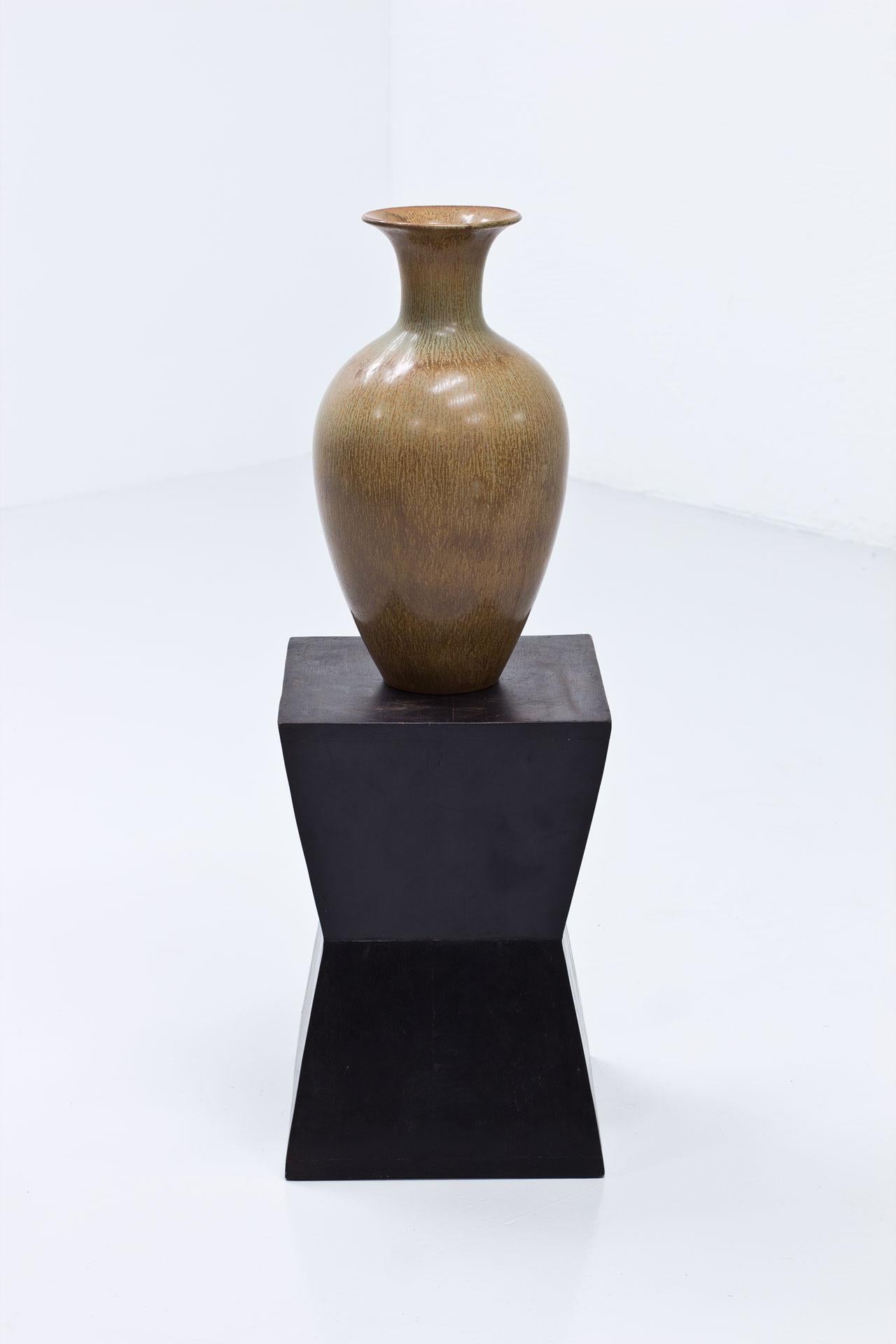 Vase de sol intemporel en céramique conçu par Gunnar Nylund. Fabriqué par Rörstrand en Suède dans les années 1950. Le vase est fabriqué en grès avec une glaçure au poil de lièvre oscillant entre le brun clair et le vert.
Bon état, deuxième tri avec
