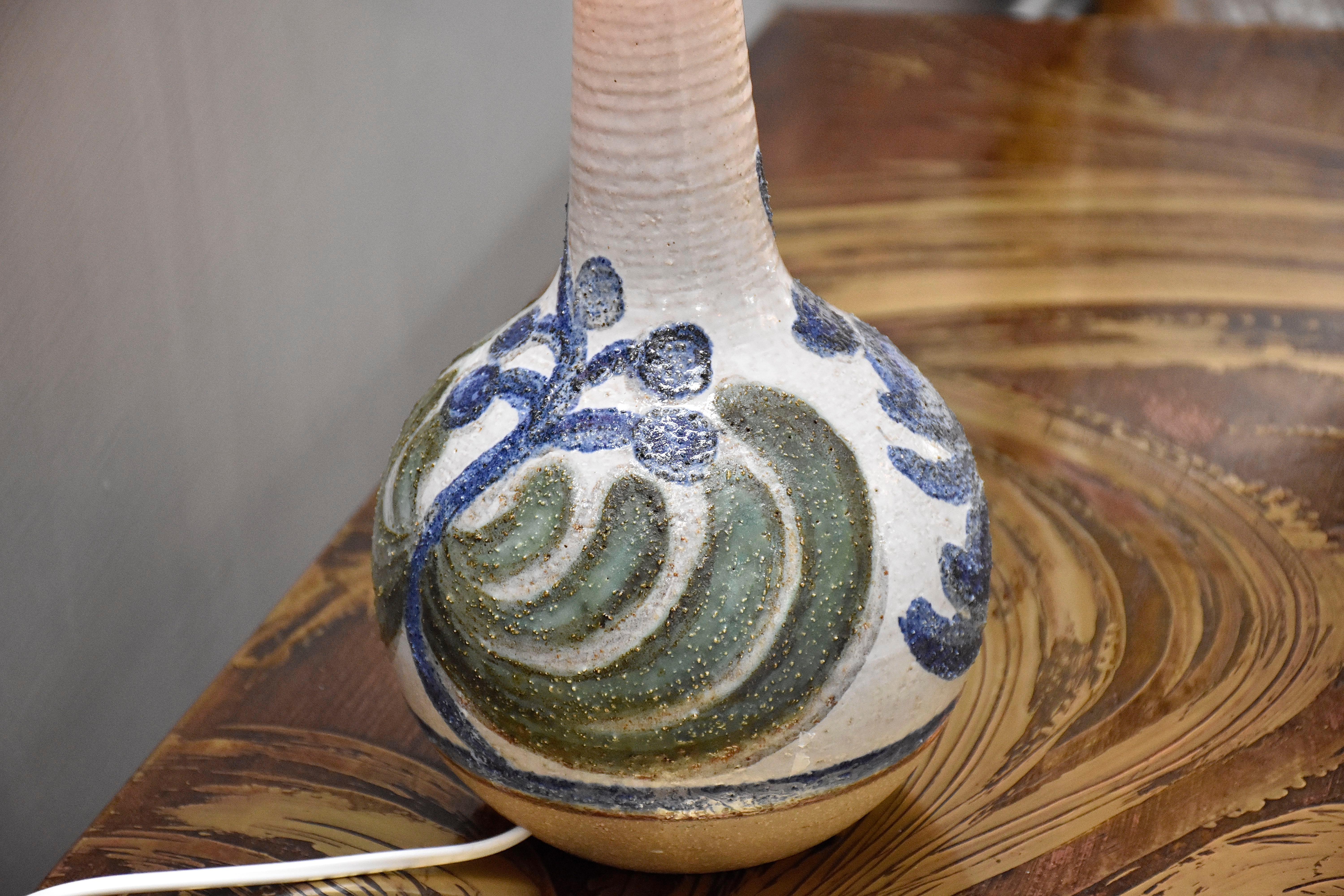 Magnifique lampe de table en céramique émaillée fabriquée par le fabricant de céramique Soholm à Rønne sur l'île de Bornholm, au Danemark (1835-1996).
Cette jolie lampe a une base beige en grès et un corps blanc émaillé avec des motifs organiques en