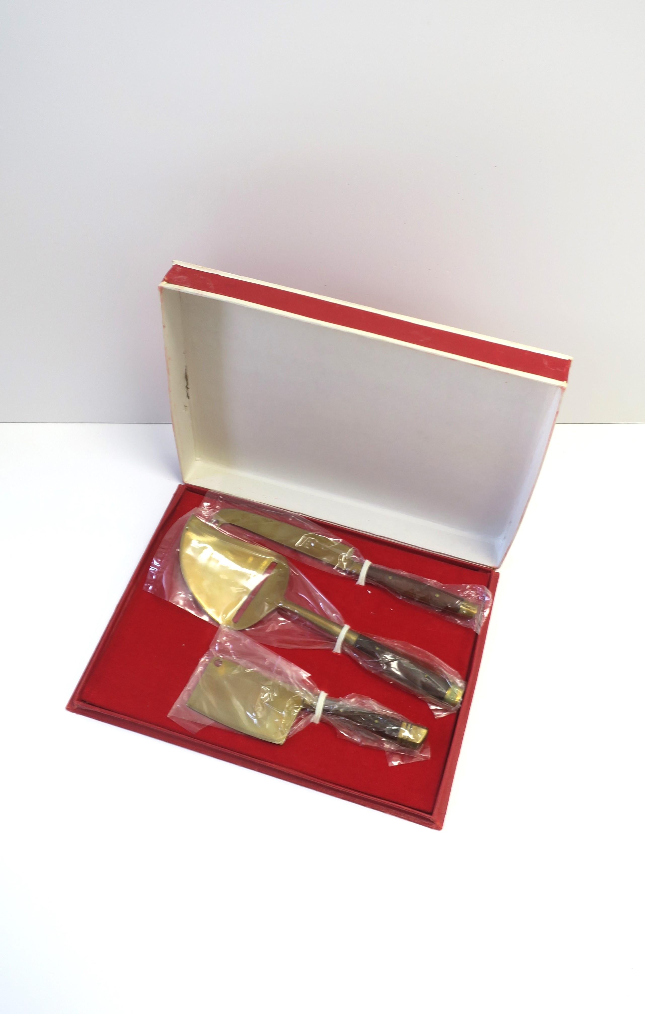 A Scandinavian Modern style rosewood and brass cheese, meat, pate, and more, cutlery set, circa mid-20th century, 1950s - 1960s. Pieces are brass with rosewood handles. A great set for everyday use or entertaining. Set has never been used (as