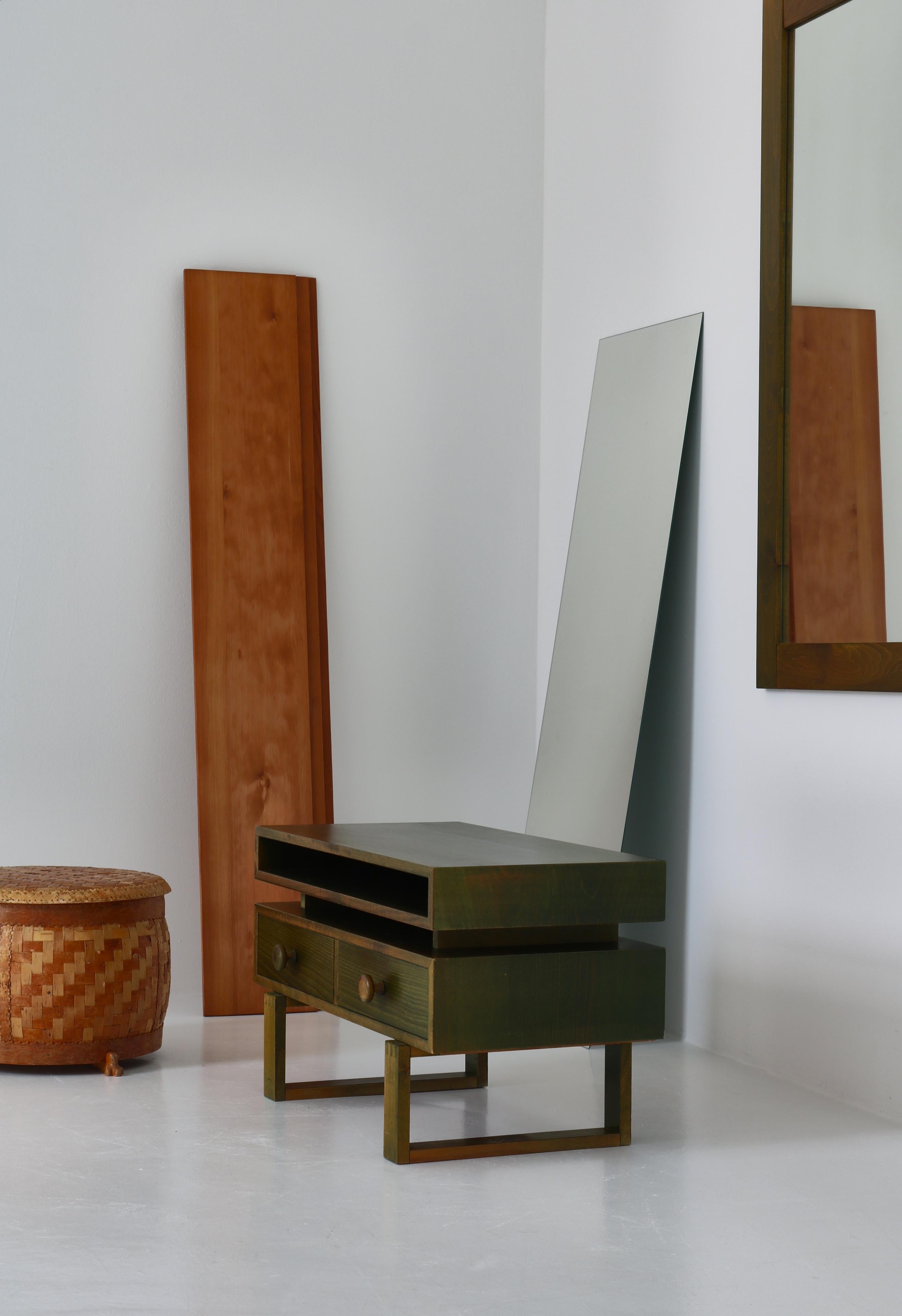 Wonderful Scandinavian Modern hallway set consisting of a low chest with two drawers and a large wall hung mirror. The was manufactured in the 1970s Denmark and is executed in solid green stained pinewood with a beautiful grain.
The pieces are