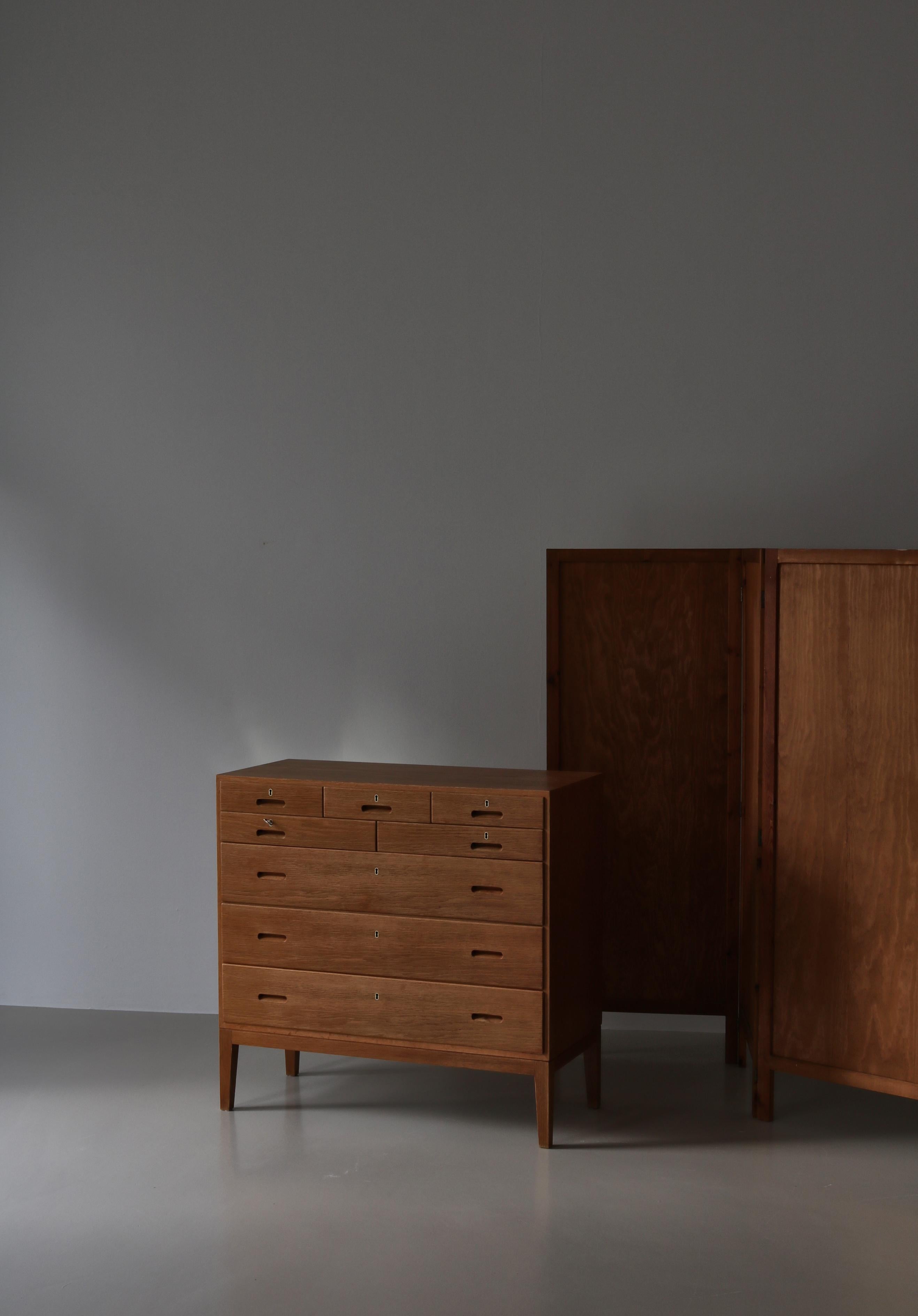 Danish Modern chest of drawers made in the 1960s at cabinetmaker P. Jeppesens and designed by Kaj Winding. Rare oak edition with 8 drawers. Elegant and simple design with beautiful details such as the carved drawer handles. Original key included.
