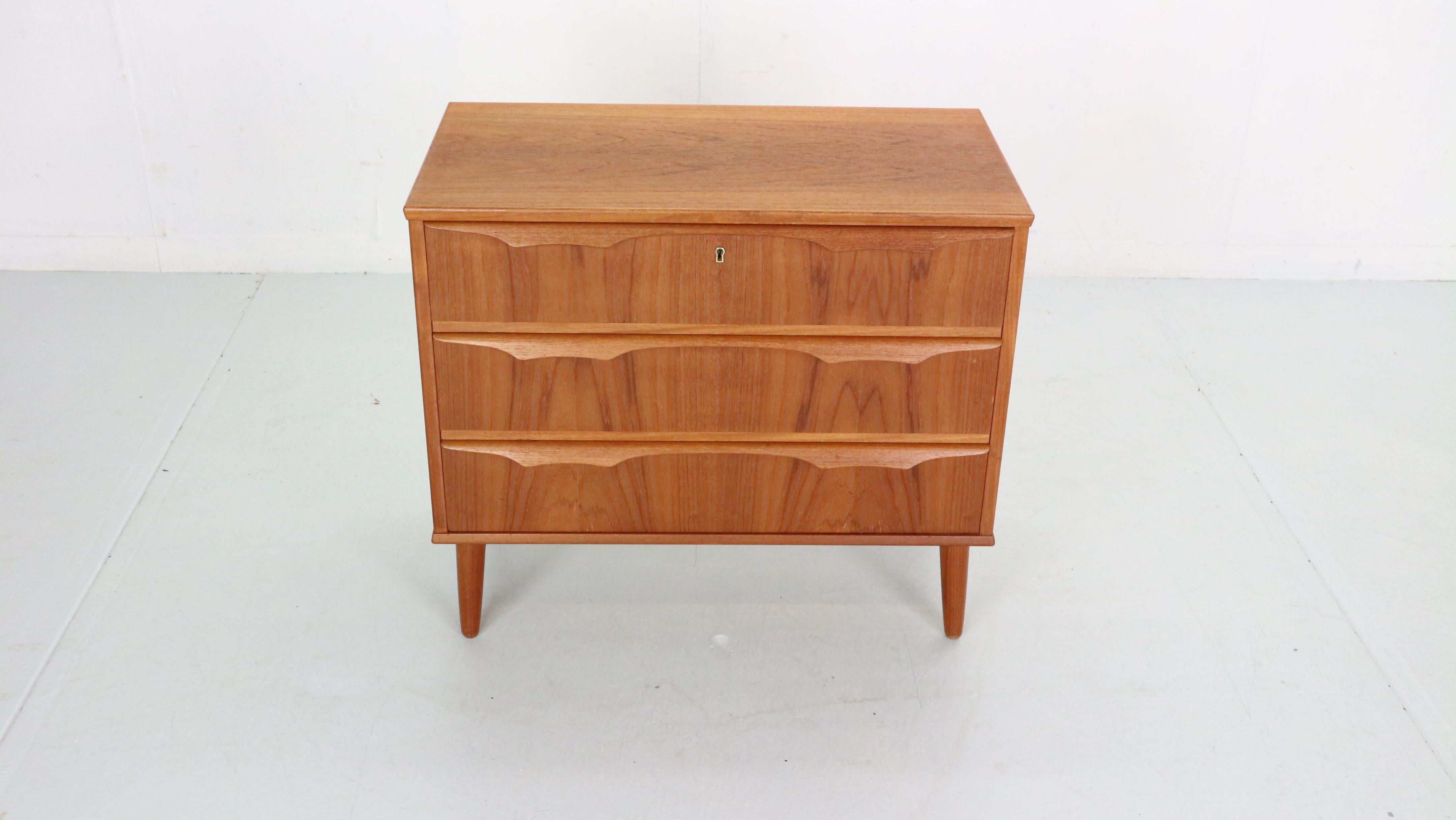 Scandinavian modern period a short chest of three drawers in teak with lipped handles by Trekanten Mobler. Denmark, 1960s.
A functional design where all the prominence falls on the expressive natural grain of the wood and sculptural handles.
The