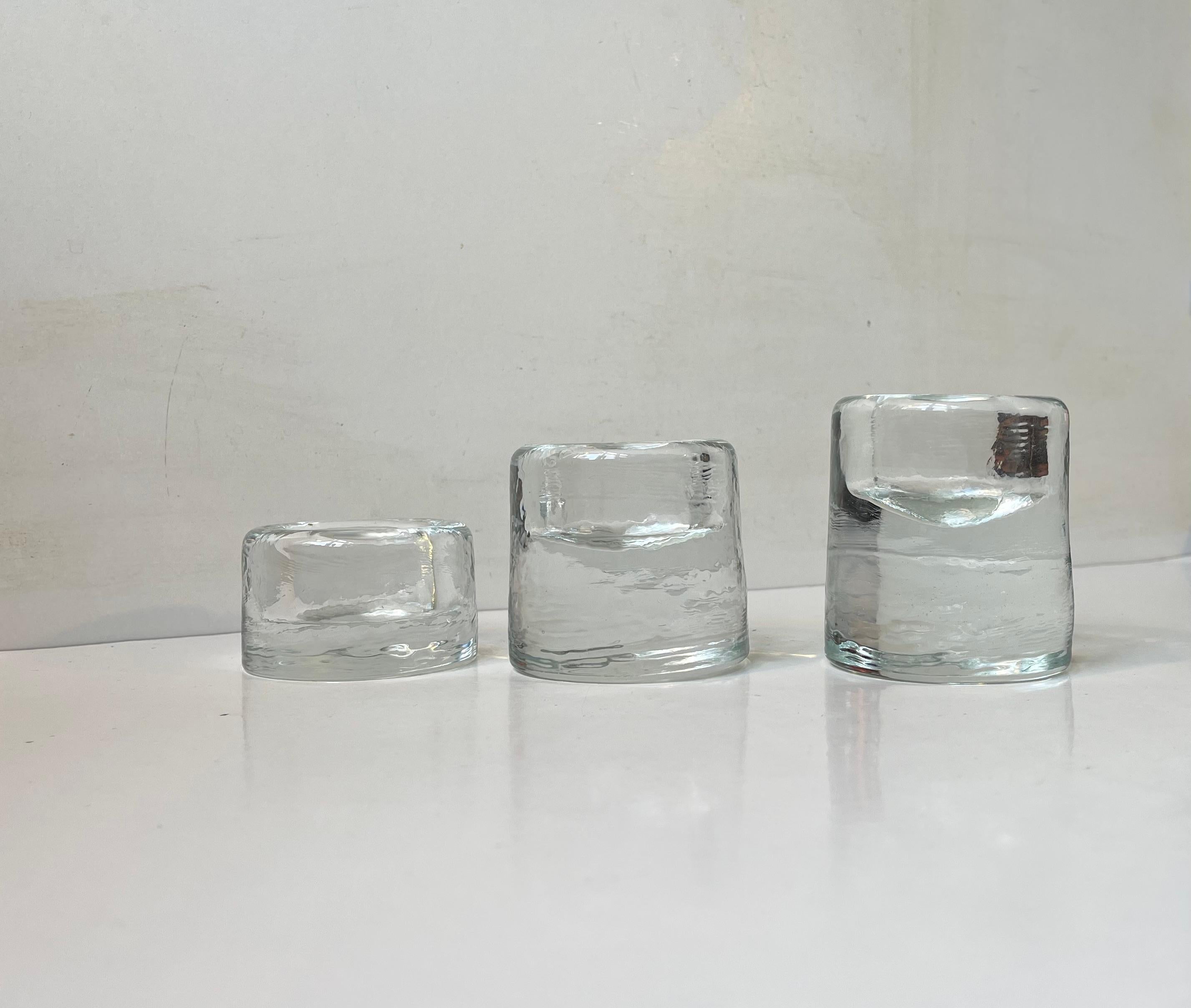 A set of 3 ice-glass chimney/cylindrical candleholder for bock, tea lights and ball lights. Unknown Scandinavian maker/designer circa 1980 in the style of Littala Finland. Wellkepot and clean. Measurements: H: 4.5/6.5/8 cm. Diameter: 7/4.5 cm