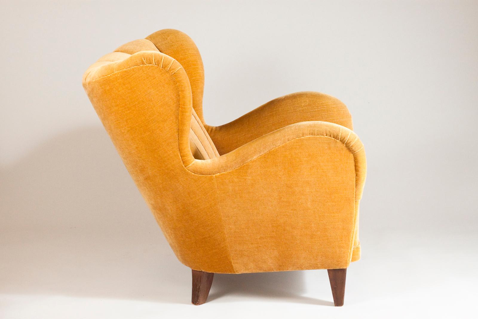 Beautiful and comfortable Scandinavian Modern club chair with decorative forms and upholstered in yellow velvet fabric.