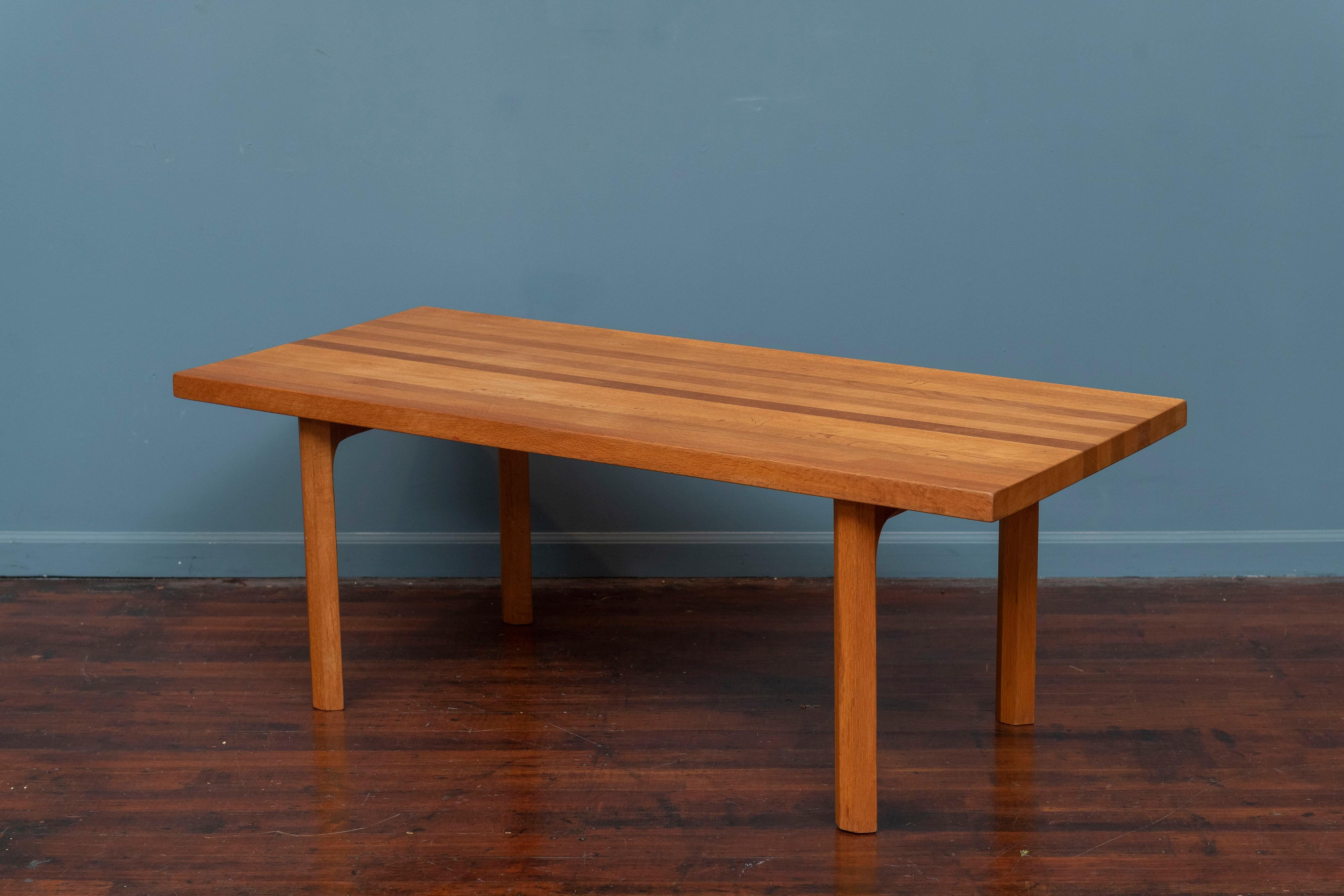 Scandinavian Modern coffee table designed by Illum Wikkelso for Mikael Laursen, Denmark. Made from solid oak in a butcher block top on sculpted legs and cross supports. Robust table that is heavy and solid suitable for heavy use but still embody