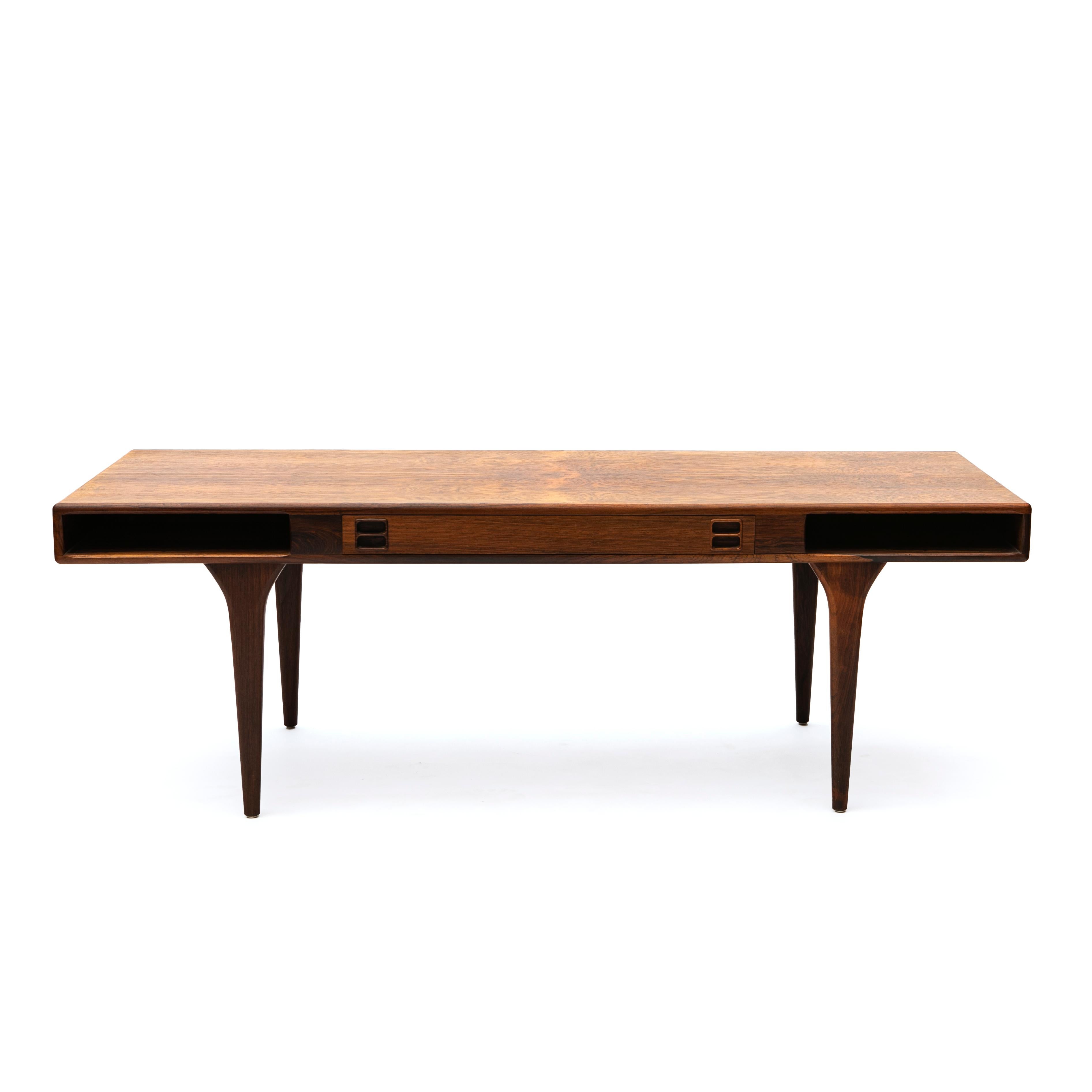 Nanna & Jørgen Ditzel design.

Rare rosewood cofee table designed by Nanna & Jørgen Ditzel.
Features one drawer and two open shelves on each side. Subtle curve to the legs.

Manufactured by CFC Silkeborg, Denmark, in the 1960's. Manufacturer’s