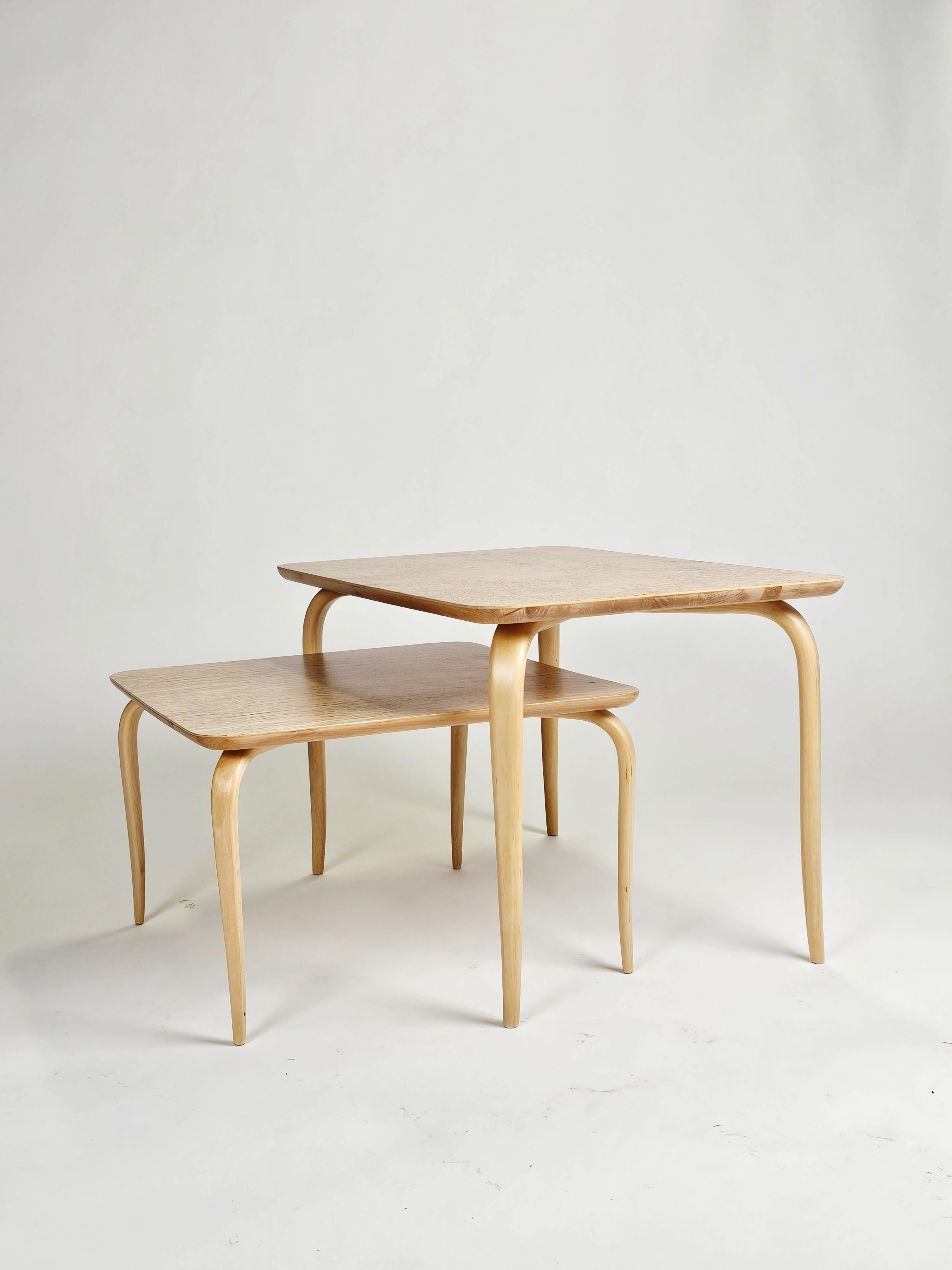 Wunderschönes Set von Couchtischen oder Nisttischen, entworfen von Bruno Mathsson für die Firma Karl Mathsson, Schweden, in den 1950er Jahren. 

Elegantes Design. 

Lockenbirkenplatte mit schönem Zustand. 

Der kleinere Tisch misst 54,5x54,5 cm und