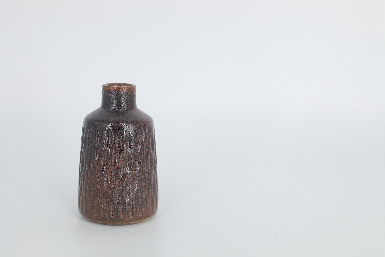 This miniature, collectible stoneware vase was designed by Gunnar Borg for the Swedish manufacture Höganäs Keramik during the 1960s. Handmade by a Master, with the utmost care and attention to details. The vase is dyed brown, with an irregular shade