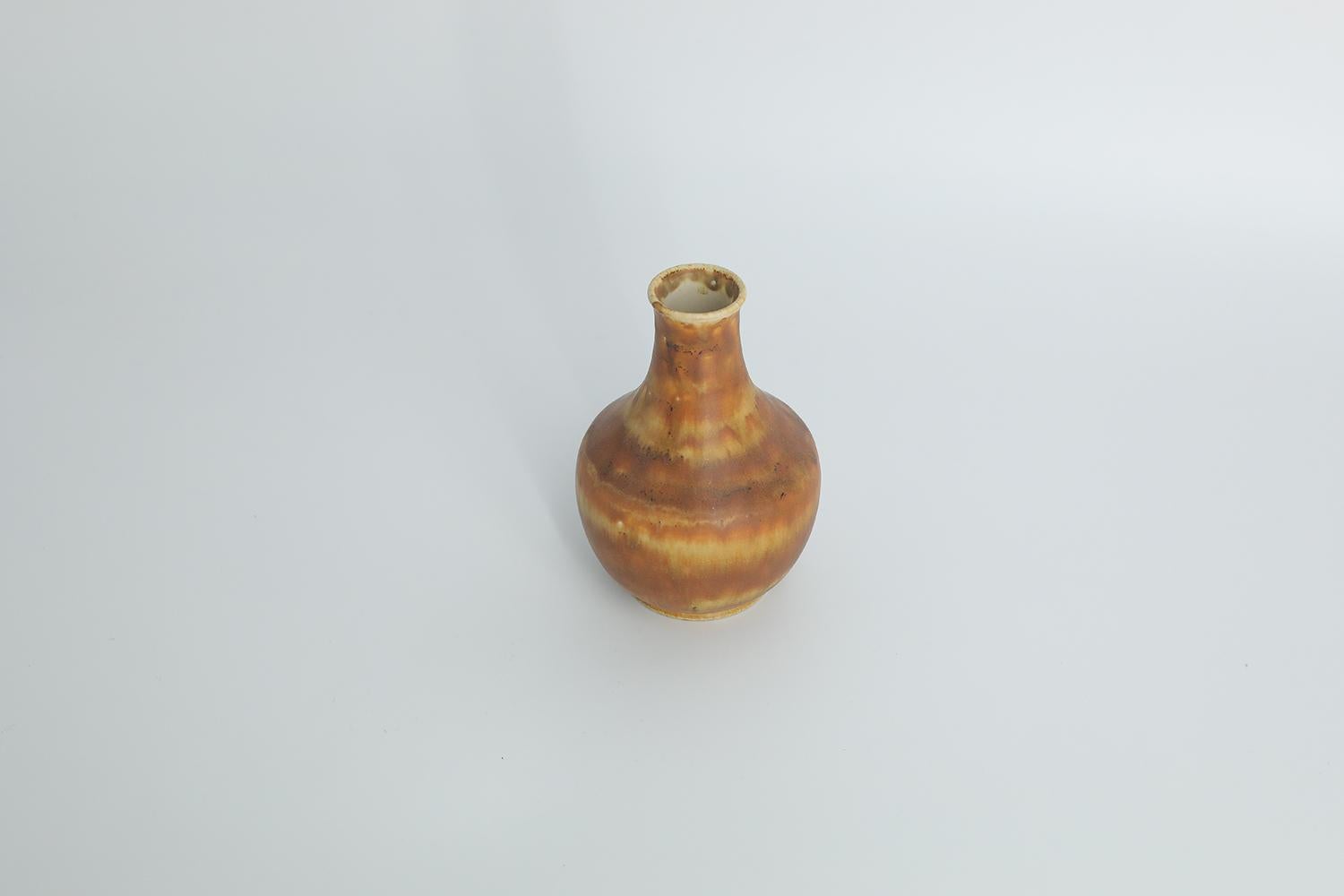 This miniature, collectible stoneware vase was designed by Gunnar Borg for the Swedish manufacture Höganäs Keramik during the 1960s. Handmade by a Master, with the utmost care and attention to details. The vase is colored in an irregular shade of
