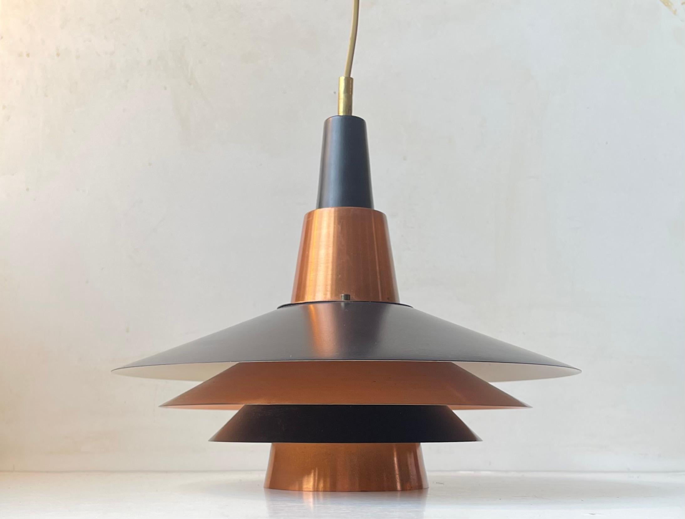 A tiered - multi-shaded Stilnovo inspired pendant lamp. Constructed from interchanging black aluminum shades and solid copper shades. Reminiscent in style to PH4 and PH5 by Poul Henningsen. It was designed and manufactured by Ernest Voss/Voss
