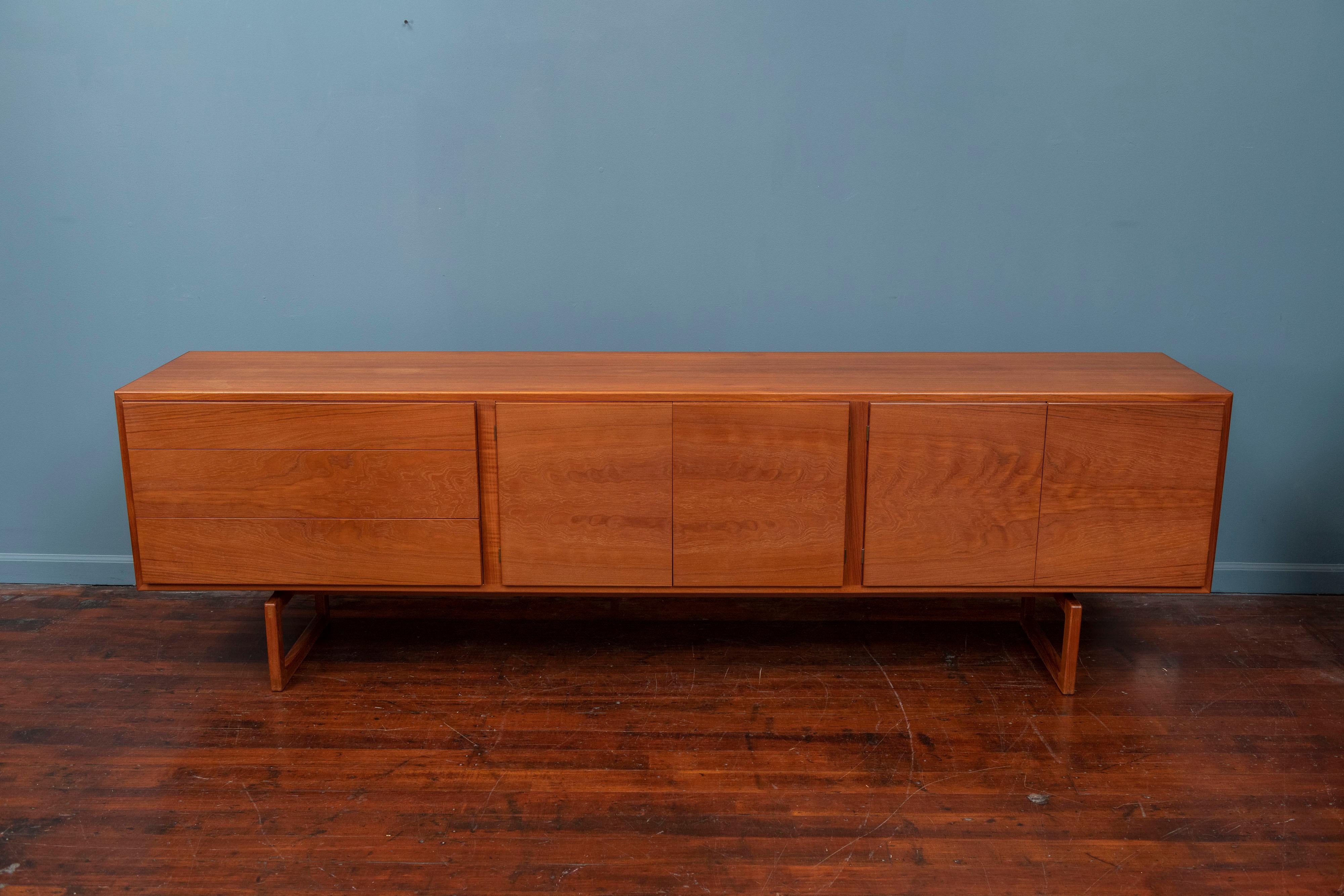 Rare Danish credenza model: MK511 designed by Arne Hovmand Olsen for Mogens Kold. Gorgeous Minimalist modernist design in solid teak. The entire front of the cabinet is made from a single piece of teak which results in a gorgeous bookmatched grain
