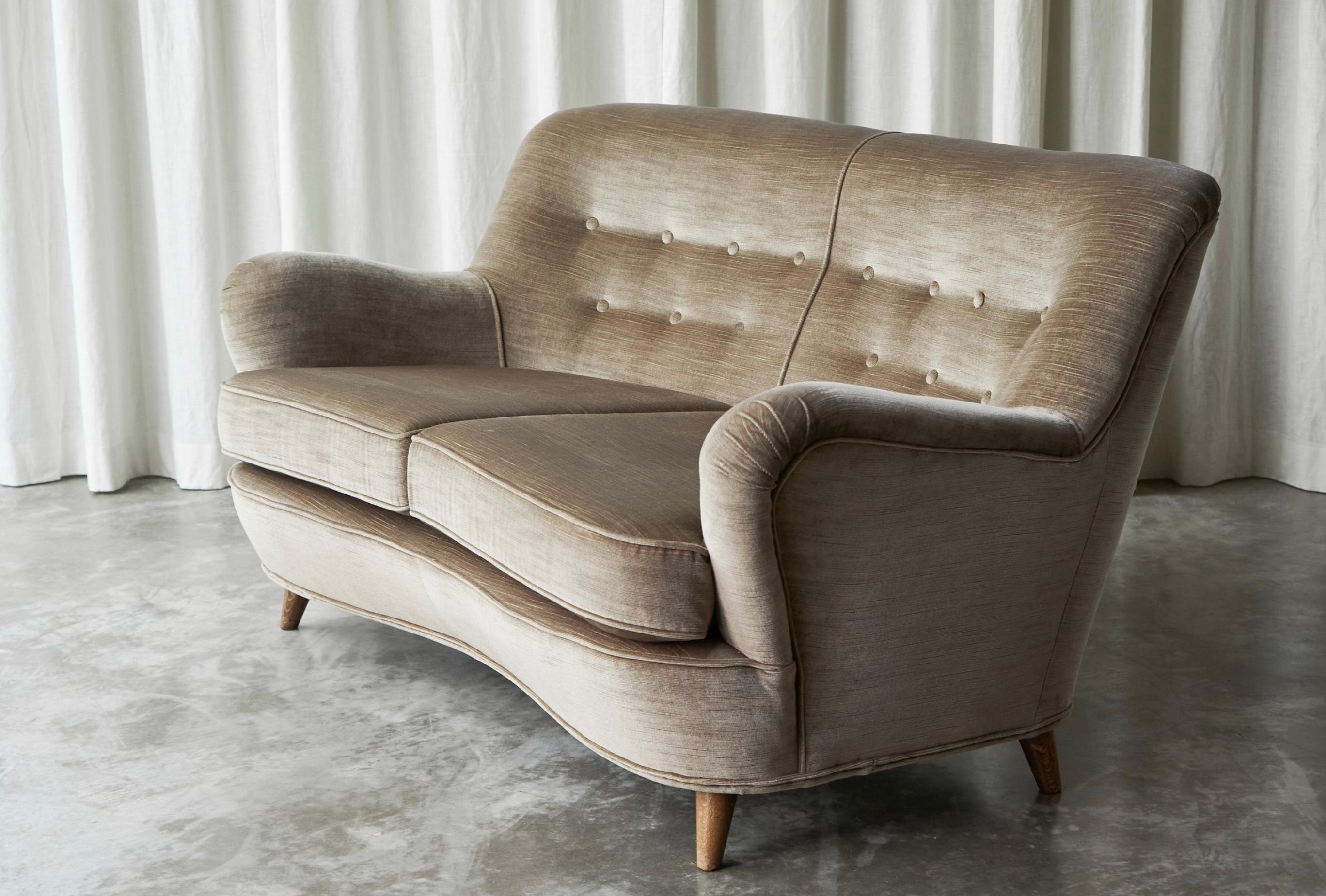 Scandinavian Modern Curved 2-seater 'Banana' Sofa in Velvet, Europe, 1960s.

This curved 2-seater 'Banana' sofa, crafted in the 1960s in Scandinavia, breathes timeless elegance and charm. The gentle curvature of the sofa's silhouette is both elegant