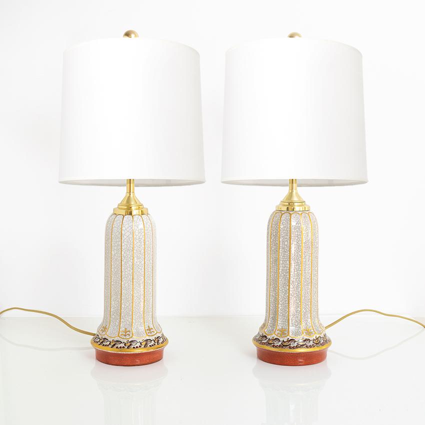Two matching Scandinavian Modern porcelain lamps designed by Jens Peter Dahl-Jensen and produced by his company Dahl-Jensen, Copenhagen, Denmark. The lamps have fluted bodies in a crackle glaze and are trimmed in gold. The base has a coral colored