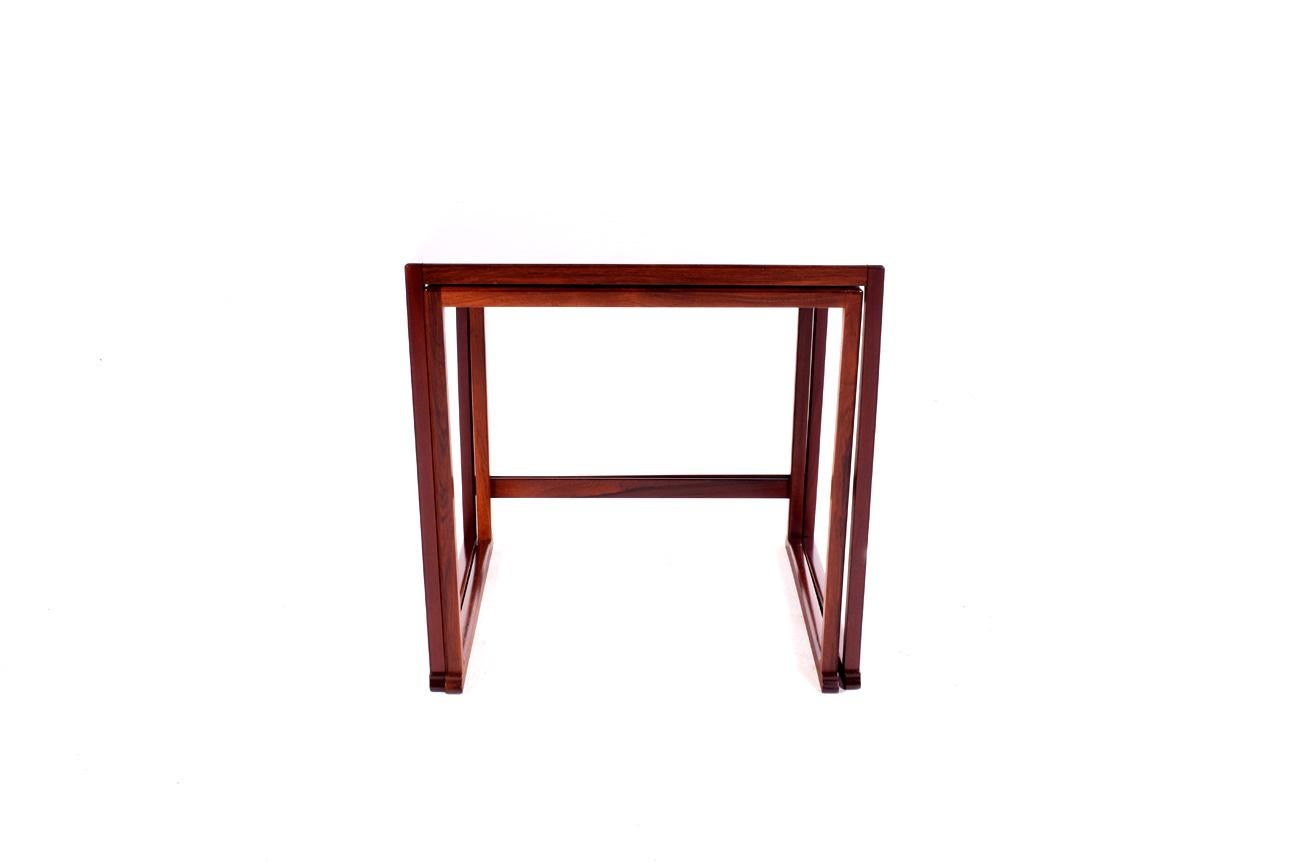 Nice set of two nesting tables rectangular. The rosewood veneer wraps over the surface and around the edges, with rectilinear rosewood frame