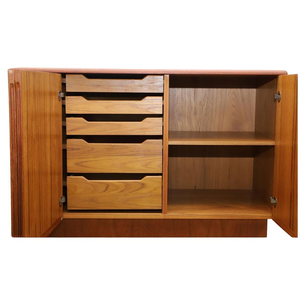 Scandinavian Danish Modern teak credenza  on a plinth base with four doors which open to three cabinets with adjustable shelving beside a cabinet with three small drawers over two large drawers. Made in Denmark. Located in Brooklyn NY.

Dimensions