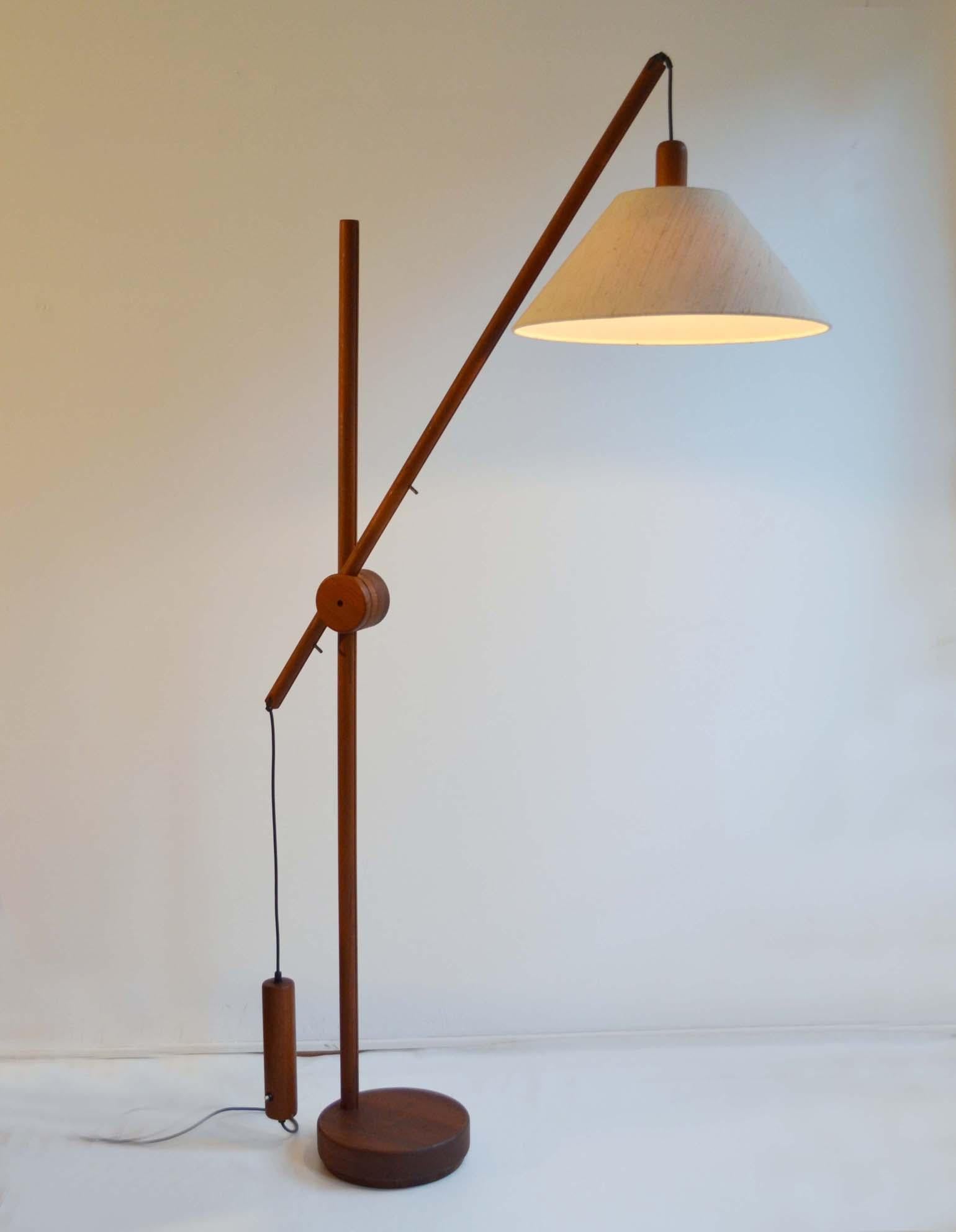 Scandinavian Mid-Century Modern floor lamp with original shade. The teak frame has an adjustable arm with counterbalance weight for perfect positioning of the light. The lamp is engineered with a lot of functional details. The original shade and