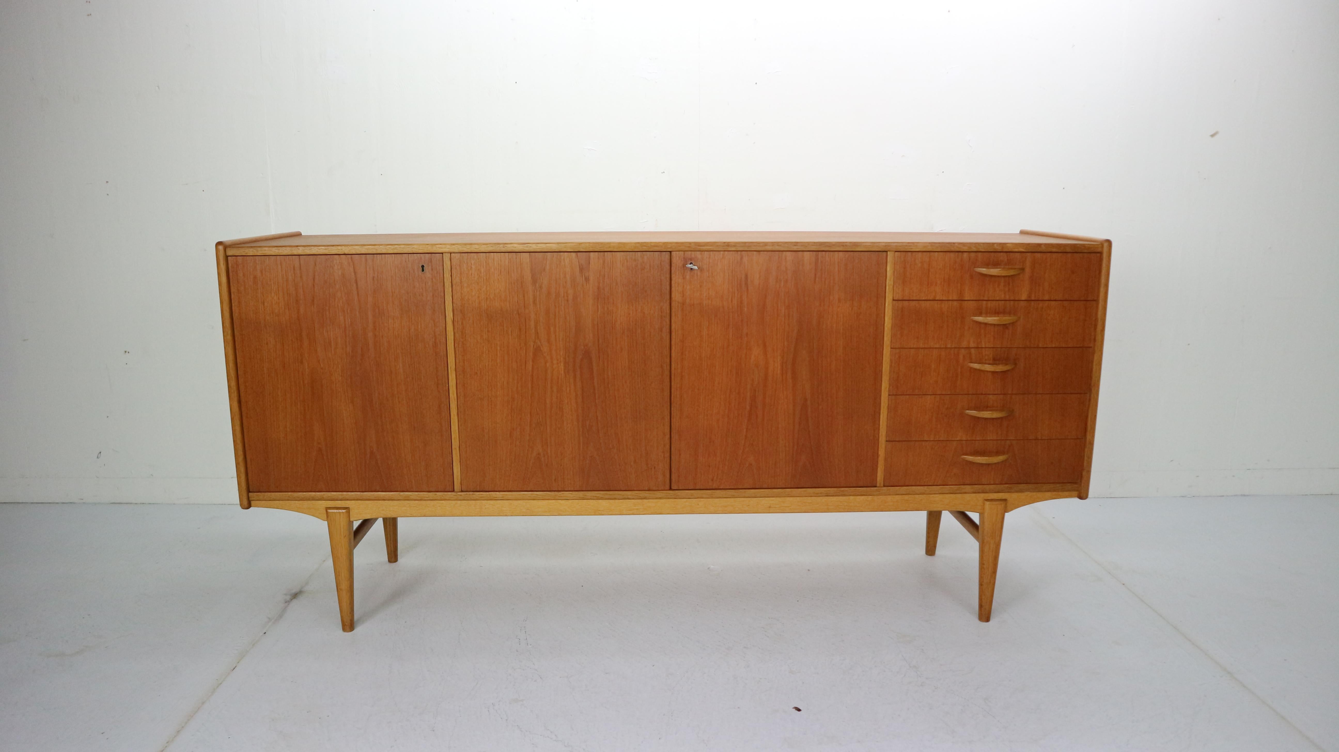 Beautifully curved Scandinavian modern period design sideboard made in 1960s, Sweden.
This sideboard is made of two types of wood. Teak main base of sideboard with beautiful wood drawings and oak solid curved feet
It has an original key and two