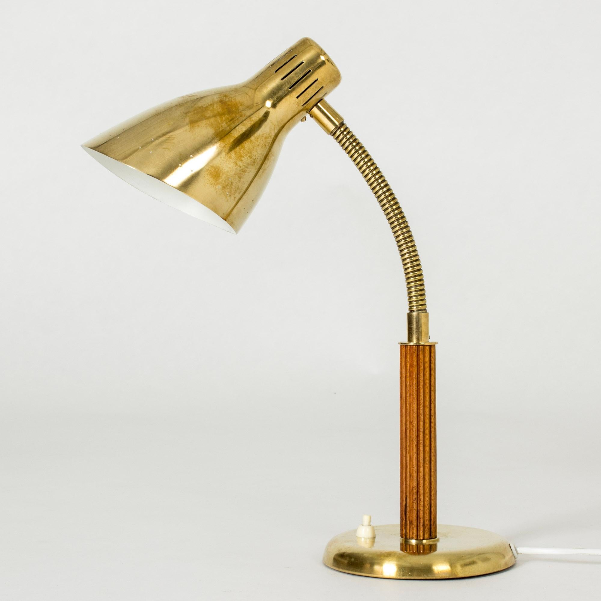 Cool lamp from Böhlmarks, with great materials. Brass shade perforated with a discreet pattern of holes, brass base, mahogany handle embossed with stripes.