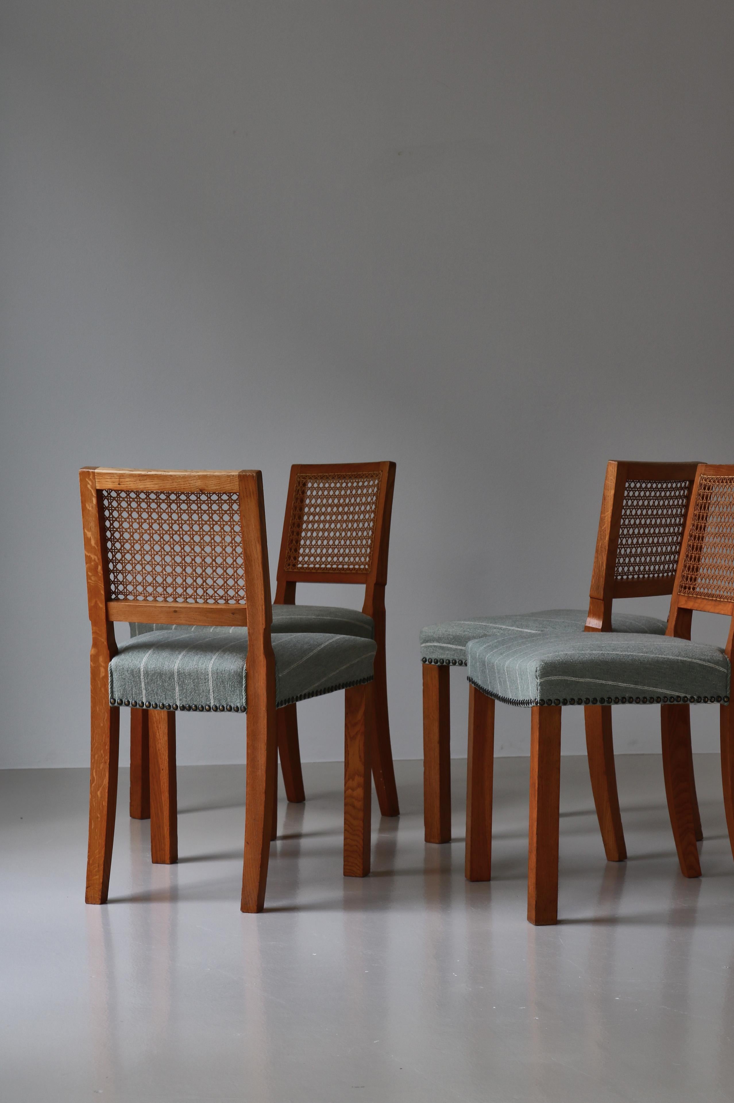 Beautiful set of 4 Danish Modern dining chairs in patinated oak & cane. The chairs were made in Denmark in the 1940s by a Danish cabinetmaker in the tradition of Kaare Klint. They are made from beautiful Scandinavian solid oak and the backs are