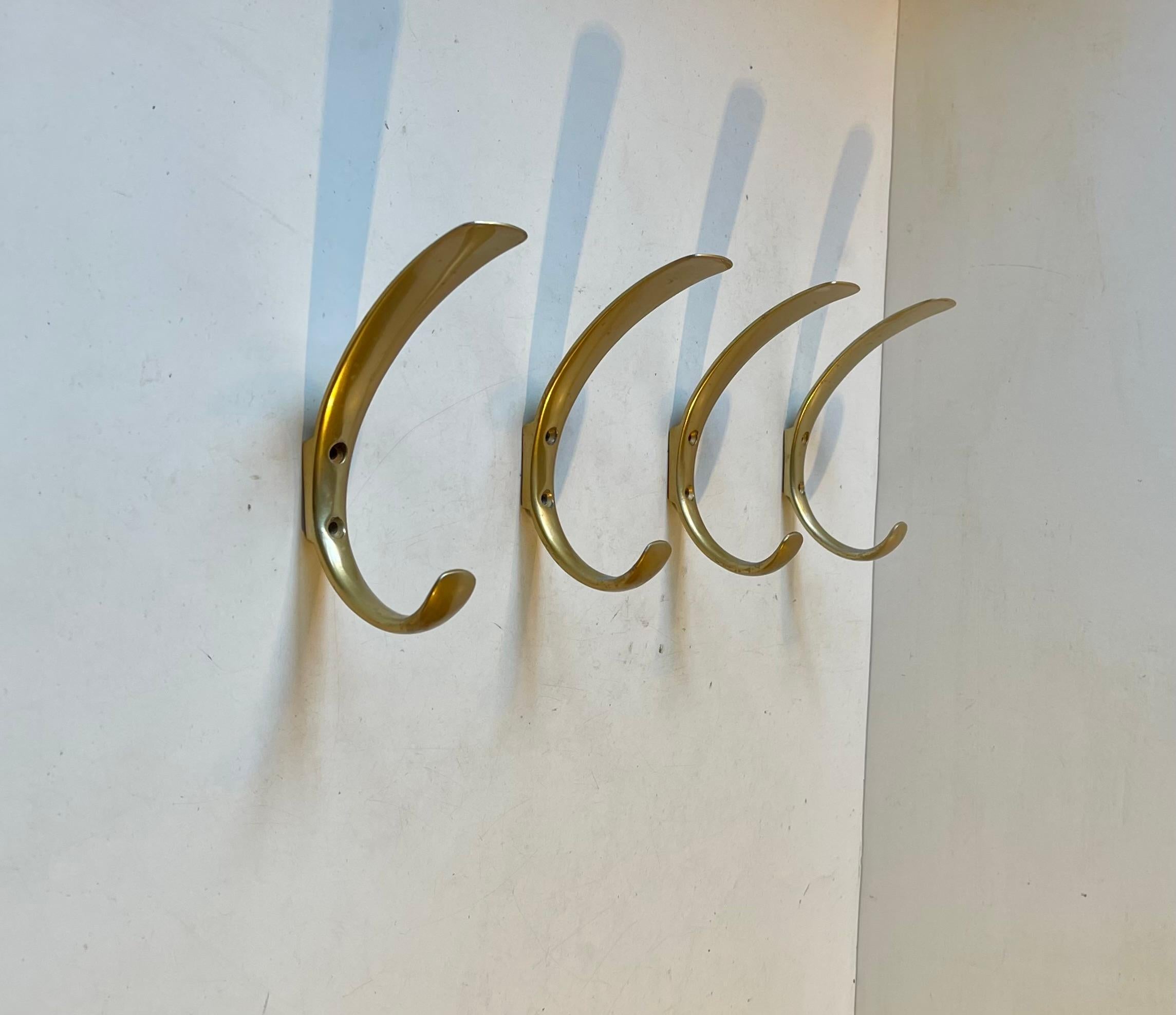 A set of 4 Scandinavian Midcentury Coat hooks for 'personalized' wall mount according to your preferences. Sleek concave organic shape. Two hanging options above/below. They are made from anodized aluminum mimic'ing brass. Made in Scandinavia circa