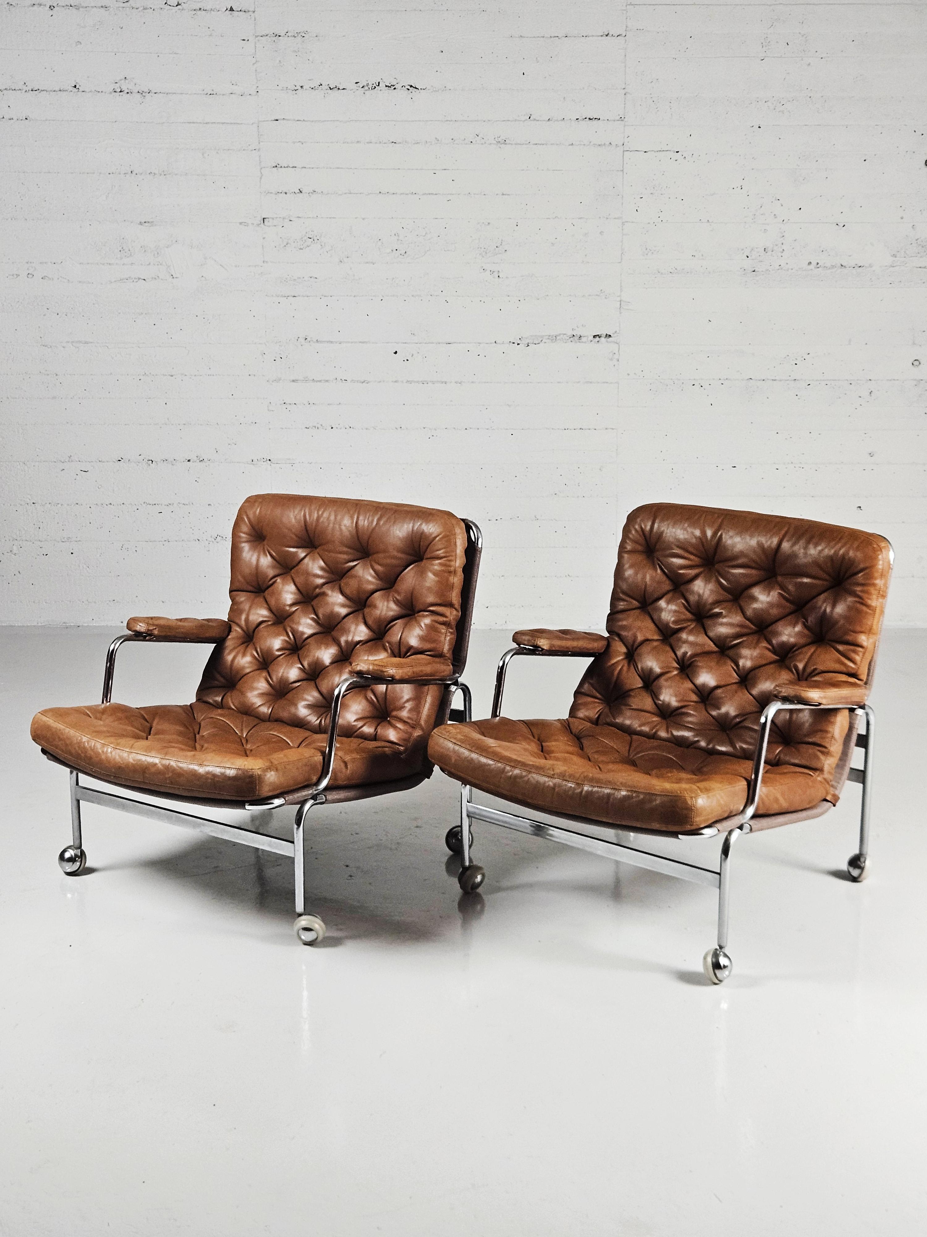 Beautiful pair of vintage 'Karin' easy chairs designed by Bruno Mathsson in Sweden during the 1970s. 

Steel frame on wheels with cushions of leather with great patina. 