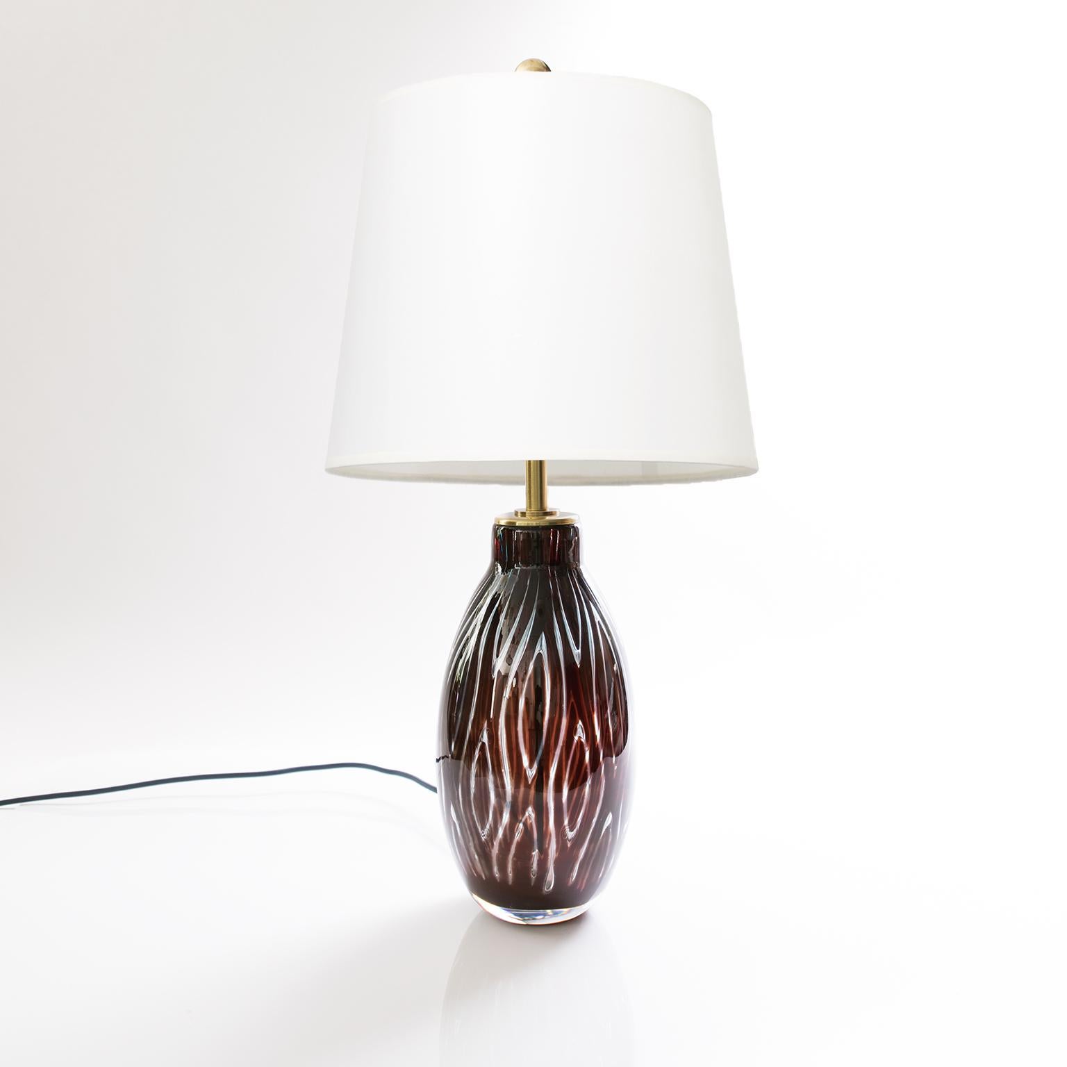 A Scandinavian Modern glass table lamp by Swedish designer Edvin Ohrstrom for Orrefors. The lamp was made using the 