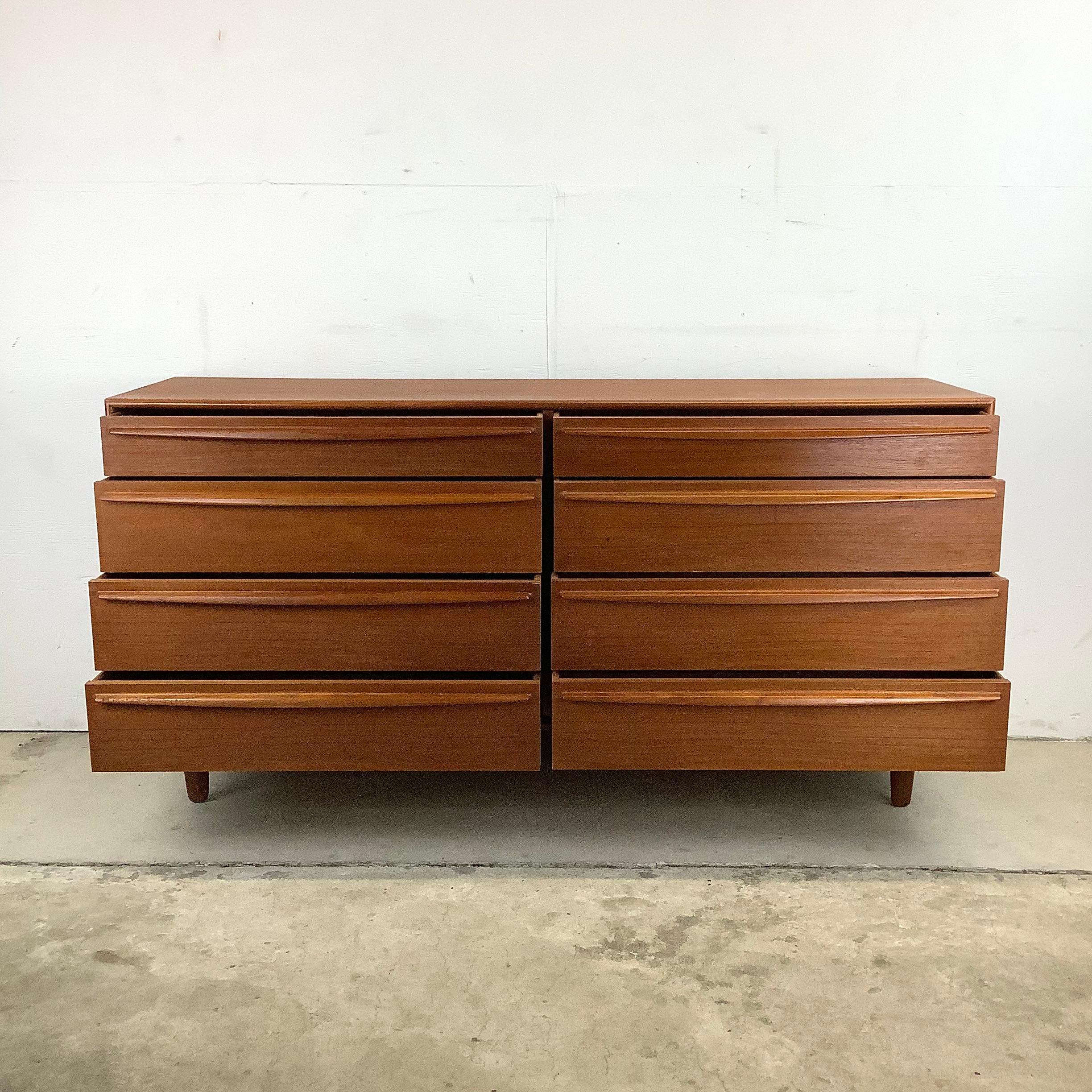 This impressive eight drawer bedroom dresser from Lyby Mobler includes a striking Scandinavian Modern teak finish and unique carved wood drawer pulls. The clean modern lines, dovetailed drawers, and exquisite Danish Modern style of this vintage teak