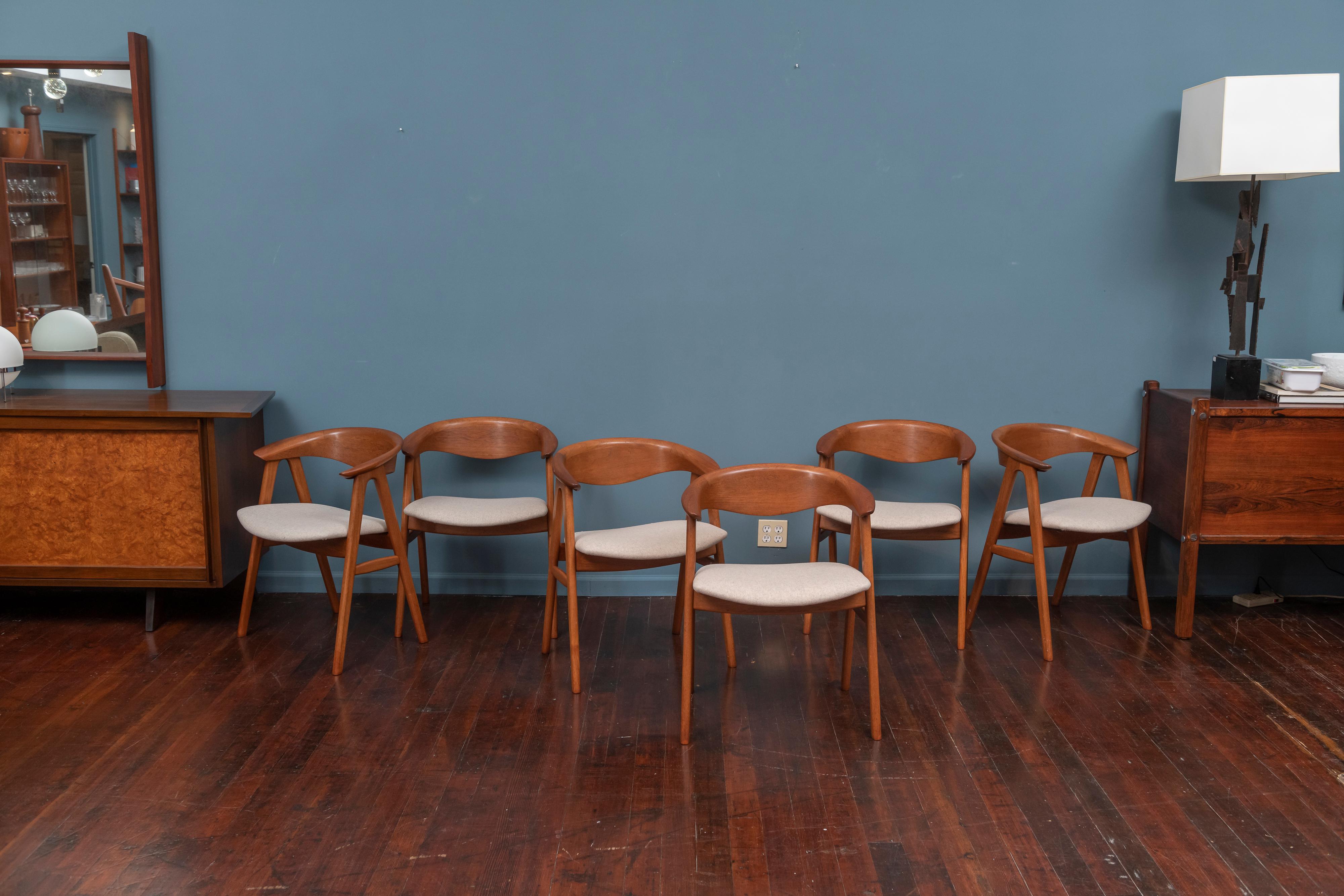 Scandinavian Modern Erik Kirkegaard design set of six teak dining chairs with newly upholstered wool felt seats. The sculptural form frames are beautiful to look at as well as very comfortable to sit in. 
The frames have been newly cleaned and