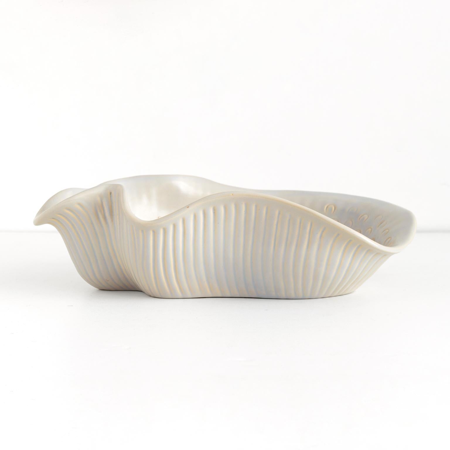 Scandinavian modern ceramic bowl in the form of a seashell in pale neutral colors. Designed by Ewald Dahlskog for Bo Fajans, Sweden, circa 1930’s. 

Measures: Length: 13.5“ width: 8.5“ height: 4“.