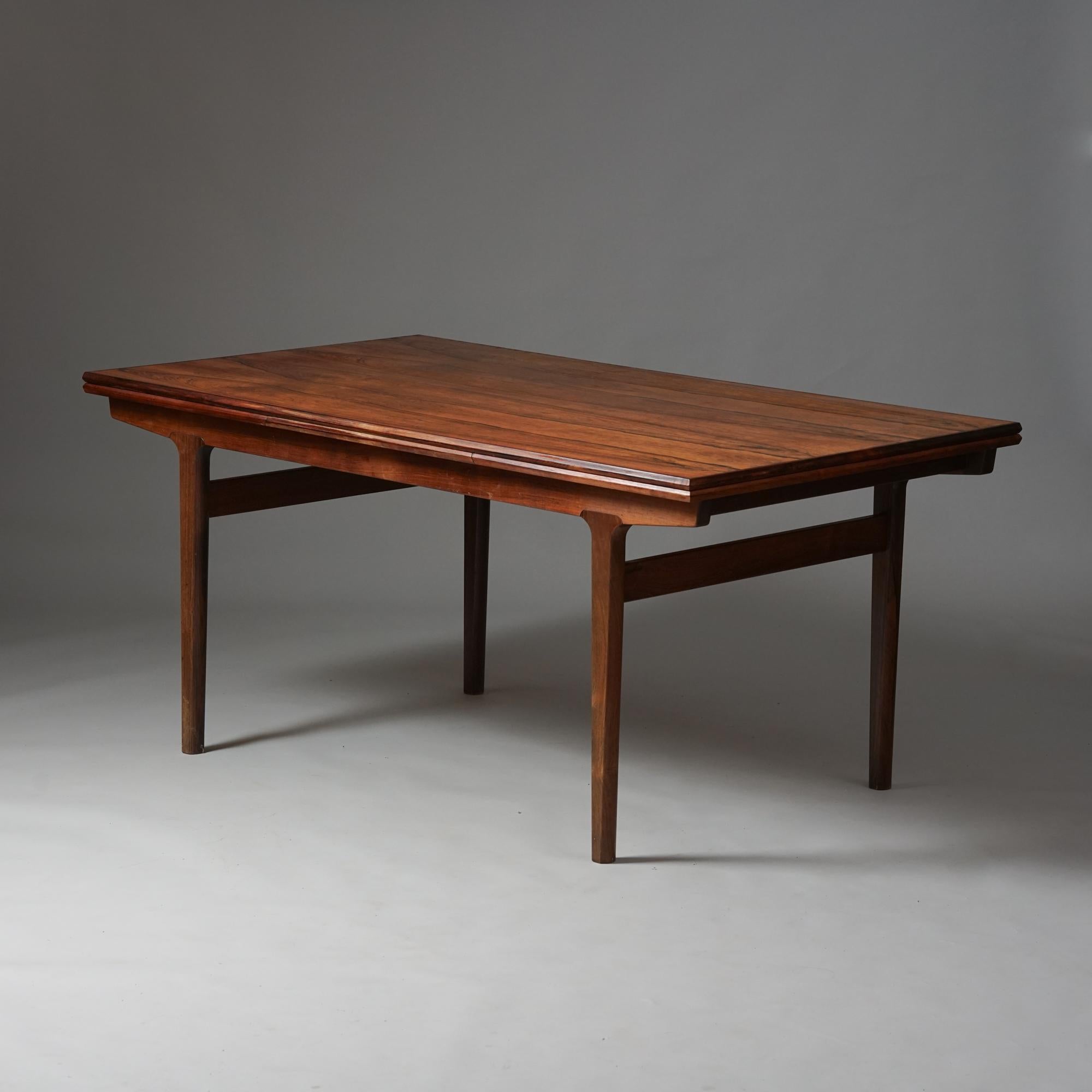 Scandinavian Modern extendable dining table, designed by Henning Kjærnulf, Denmark, 1960s. Palisander. Two extension pieces stored on both ends of the table. Good vintage condition, patina and wear consistent with age and use. 

Measurements: length