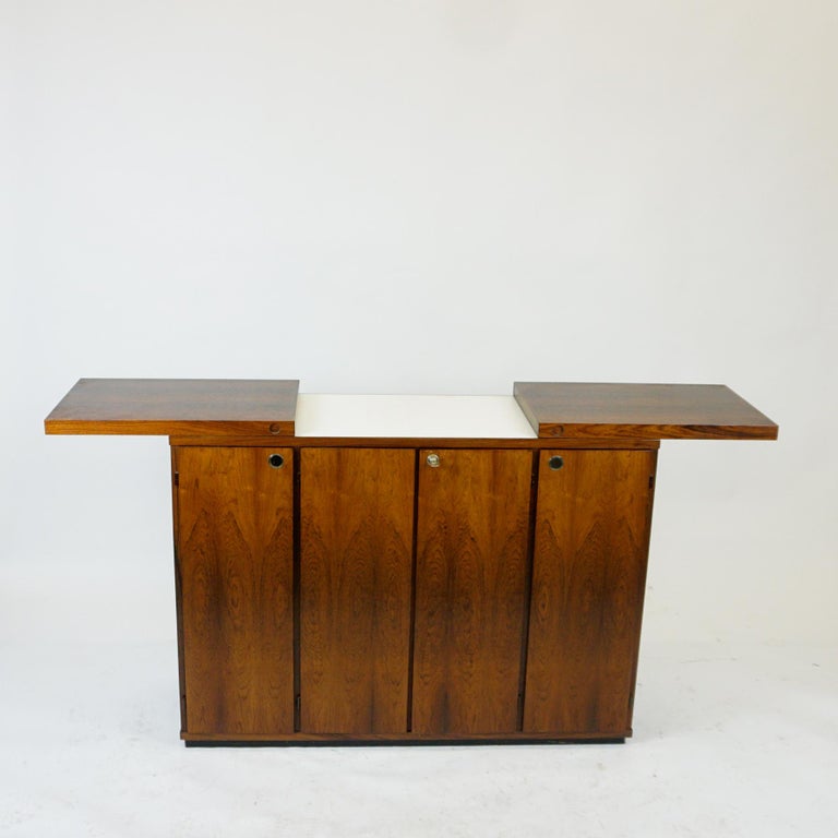This amazing and rare scandinavian modern Dry Bar Cabinett was produced by Dyrlund Denmark in the 1960s. Its Design is very close to another Bar Model designed by Reno Wahl Iversen so this one can be attributed to him as well.
It features a