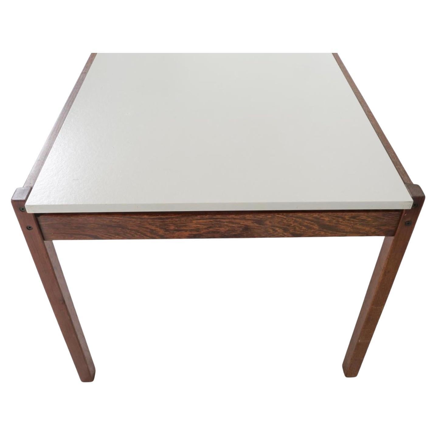 An extending dining table designed by Cees Braakman for Pastoe featuring a white Lacquer sliding top mechanism that reveals an integrated leaf for extension on one side of table. Solid wood frame. Made in the Netherlands circa 1960s. 

Dimensions: H