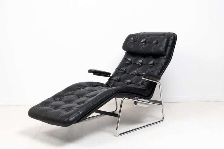 Sam Larsson lounge chair 'Fenix' for DUX. The chair is from the second half of the 20th century. Chromed metal frame with a canvas seat and detached cushions upholstered in black leather. The head rest is also detachable with leather straps. Good