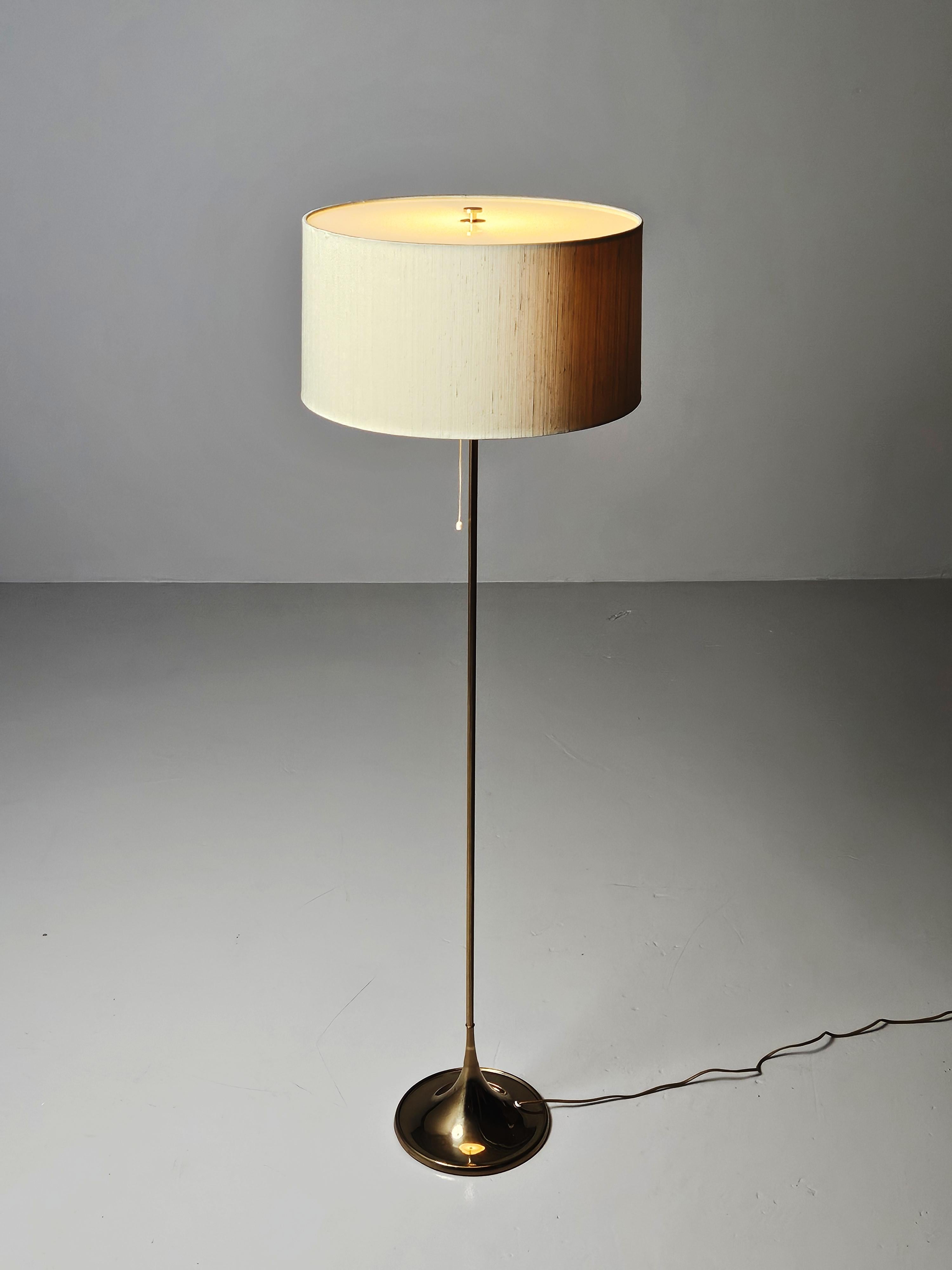 Bergboms floor lamp model 'G-026' produced in Sweden during the 1970s.

Made in brass with a modernistic design. Original large sized shade with a plastic top that produces a soft light.