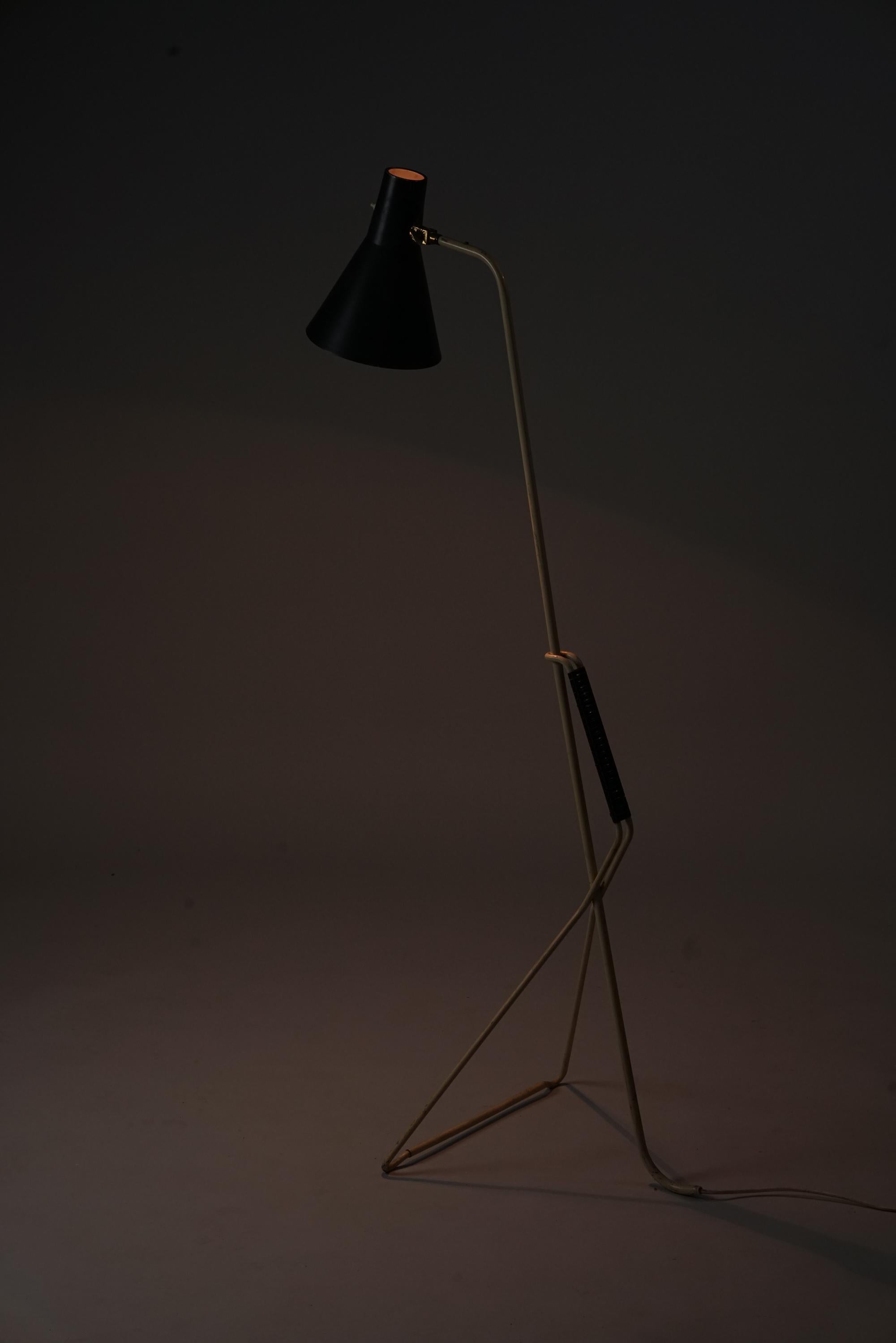 Scandinavian Modern floor lamp by Valinte Oy, 1950s. Painted metal with plastic wrapping and brass details. Good vintage condition, heavy patina consistent with age and use. 