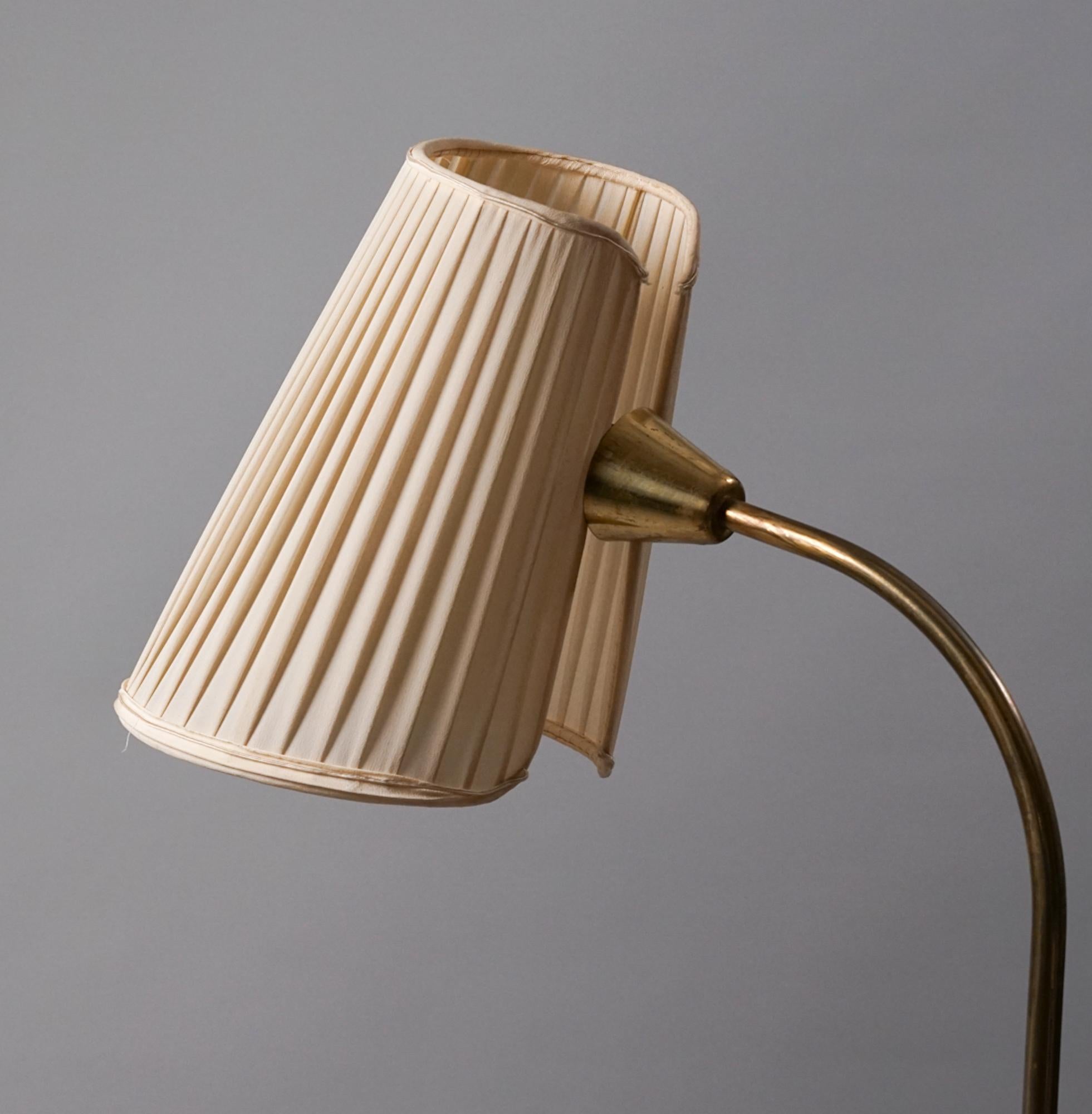 Scandinavian Modern floor lamp, manufactured by Stockmann/Orno Oy, 1950s. Brass with silk lampshade. Good vintage condition, minor patina consistent with age and use. Beautiful minimalistic design. 