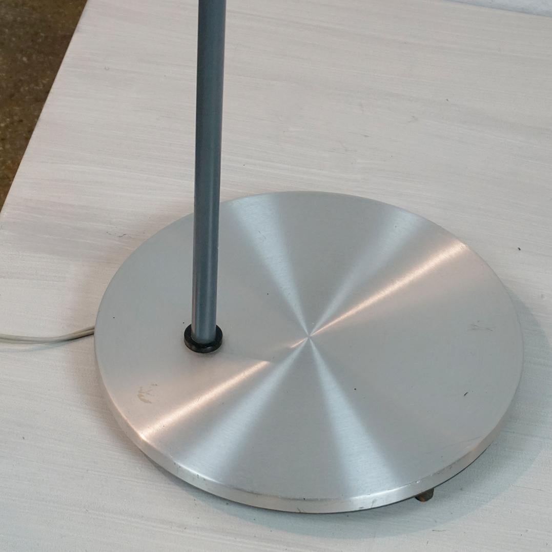 Questa iconica lampada da terra scandinava moderna Model A è stata progettata da Jo Hammerborg e prodotta da Fog and Morup nei primi anni '60 in Danimarca.
Presenta uno stelo in metallo laccato grigio e una base e un paralume in alluminio. Il