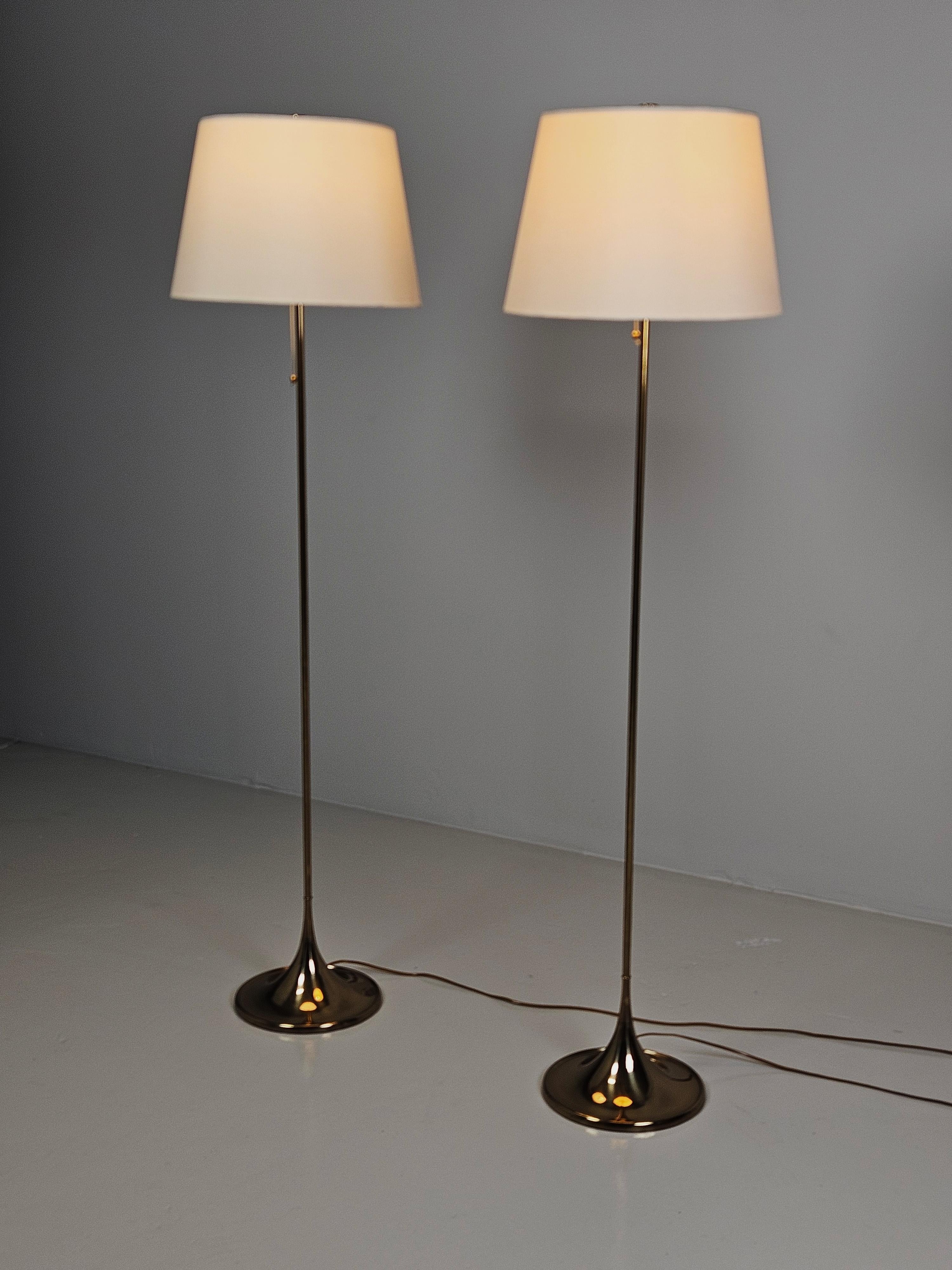 Pair of Bergboms floor lamp model 'G-026' produced in Sweden during the 1970s. 

Made in brass with a modernistic design. Original shades with a plastic top that produces a soft light. 