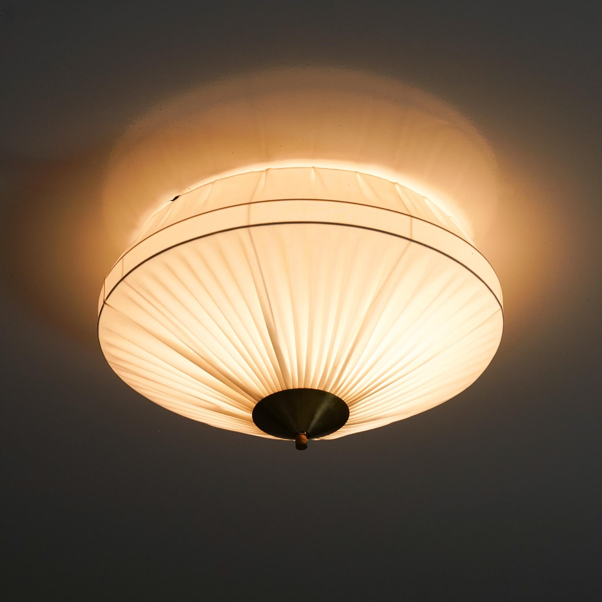 Scandinavian Modern flush mount, manufactured by Valinte Oy, 1960s. Reupholstered fabric shade, brass details. Good vintage condition, minor patina consistent with age and use. 