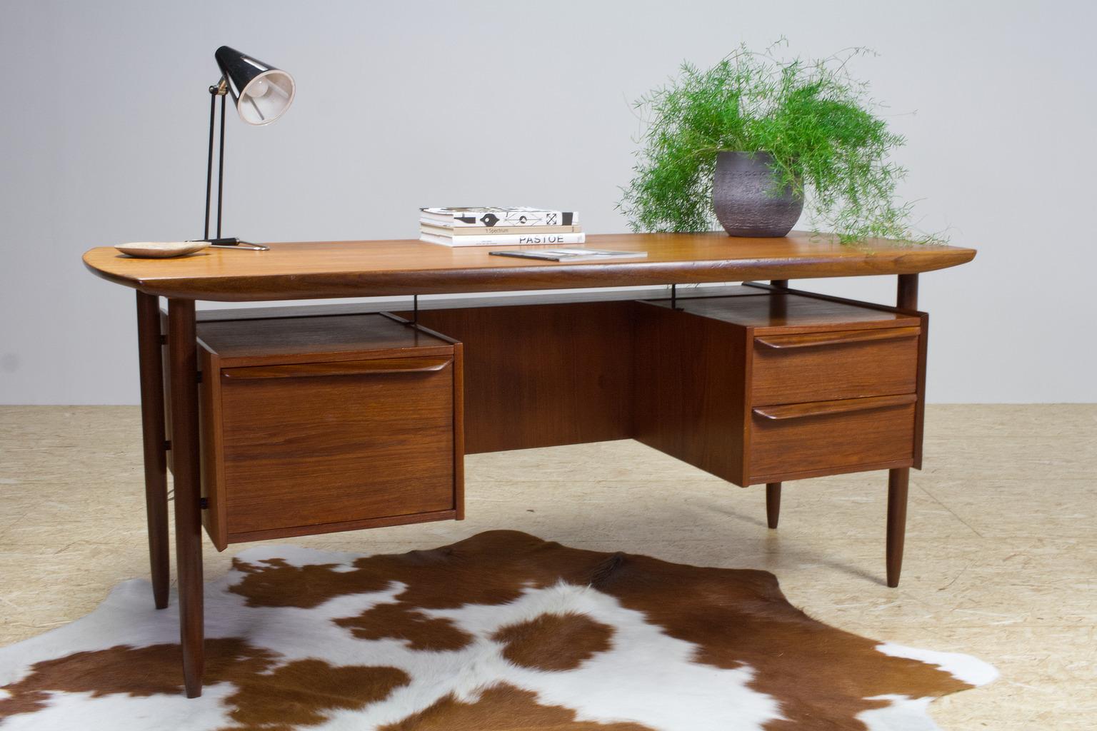 Freestanding 1960s Danish writing desk in solid teak, the design is in manner of Peter Løvig Nielsen. Danish origin, yet designer unknown. The desk has an open storage compartment in the back, which makes this a great object to stand alone in your