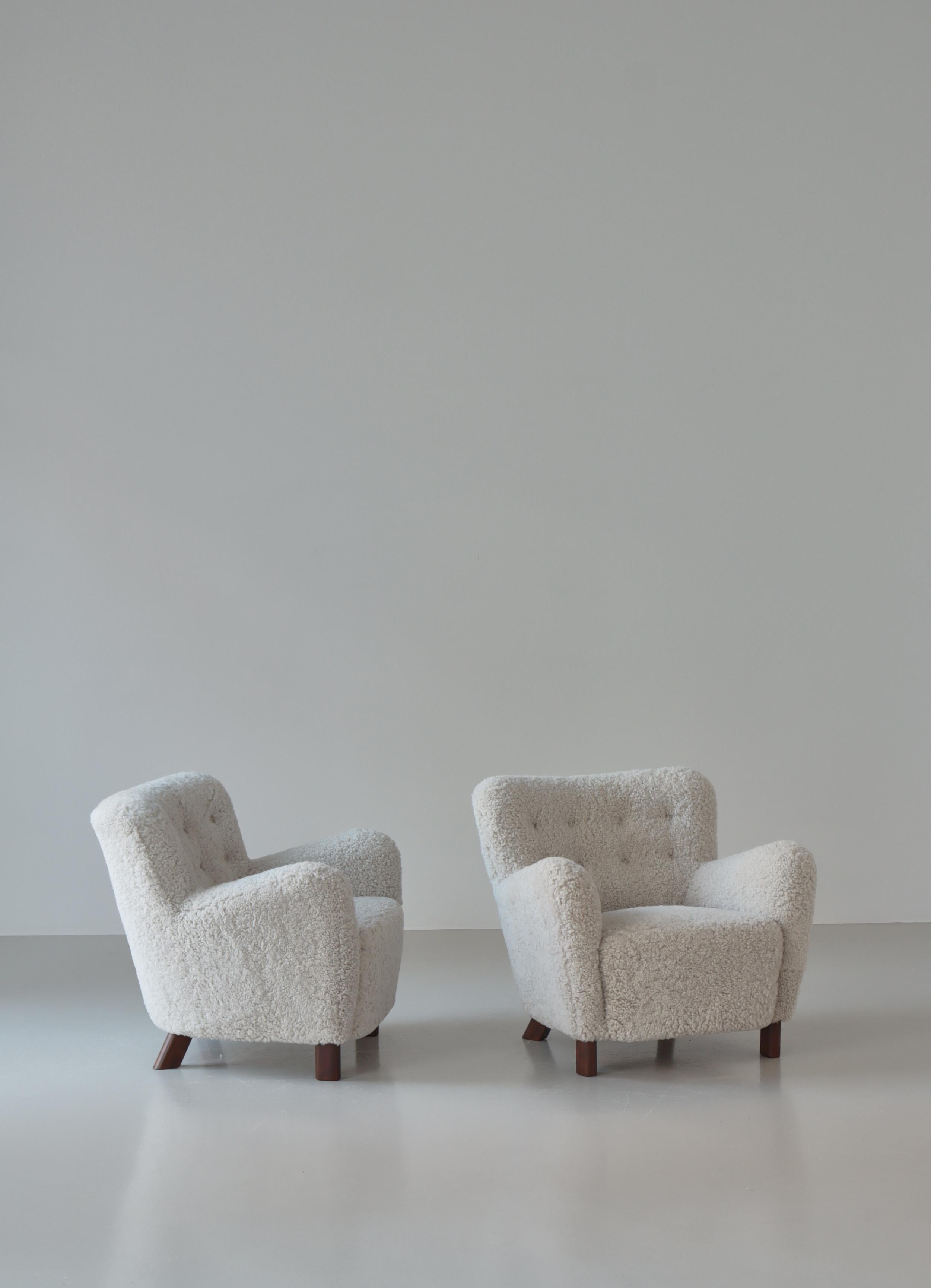 Wonderful pair of Fritz Hansen model FH-1669 lounge chairs from the original licensed  production in the 1940s. The chairs have been refinished and reupholstered in best quality shearling 