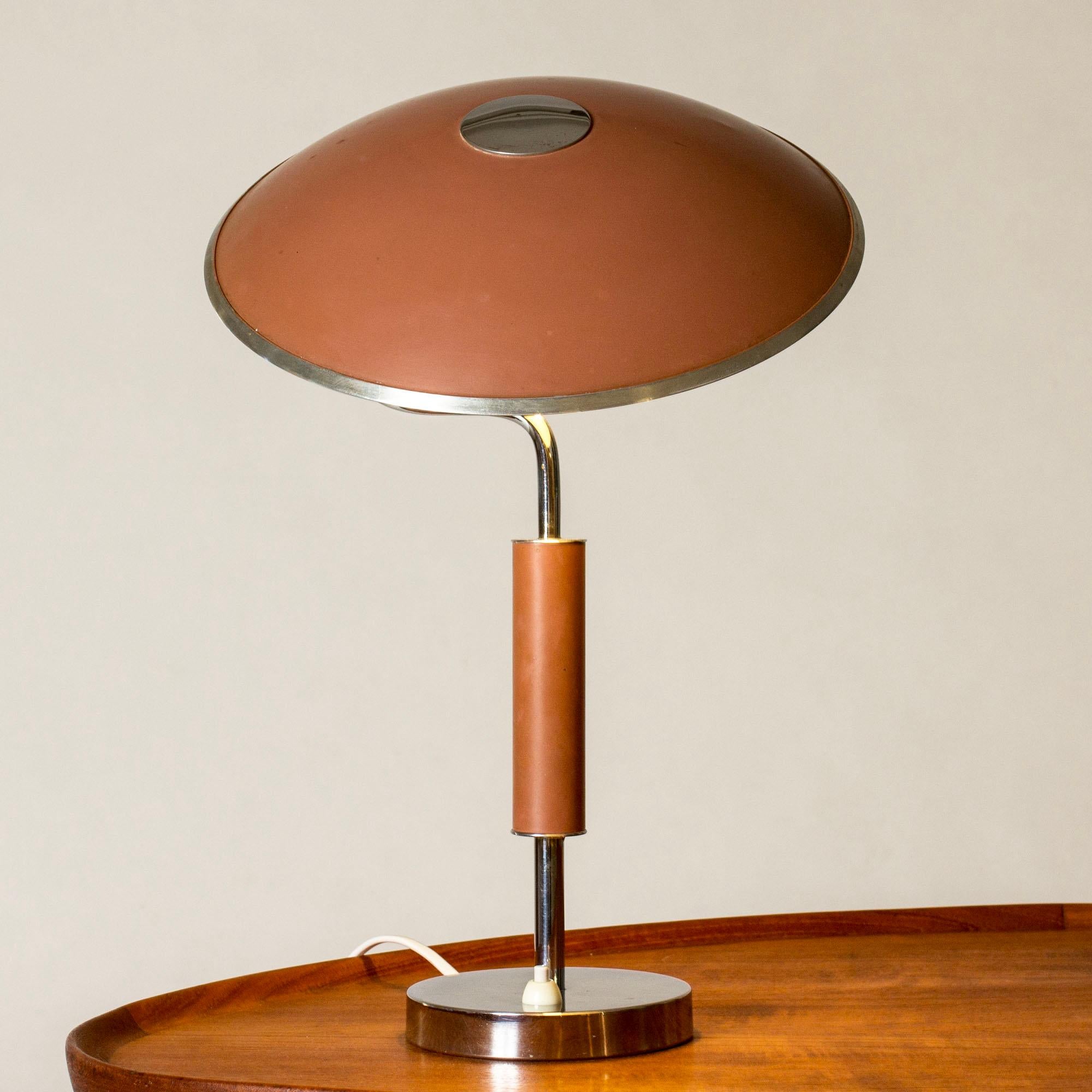 Lovely table lamp from Böhlmarks, made from brass with a large shade lacquered dark green. The key detail on top of the shade lights the lamp when turned.