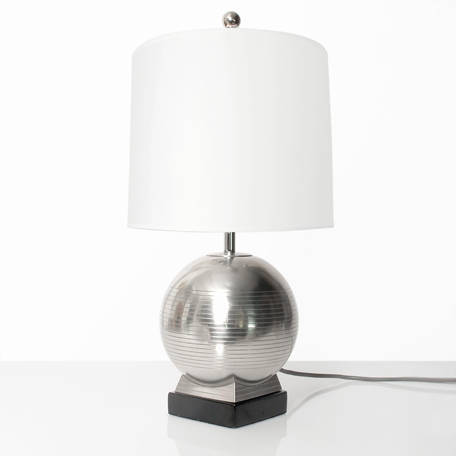 A Scandinavian modern spherical pewter table lamp on a lacquered wood plinth detailed with a series of horizontal groves. Made by G.A.B. (Guldsmedsaktiebolaget), circa 1930s. Newly polished, lacquered and rewired for the USA with a nickel-plated