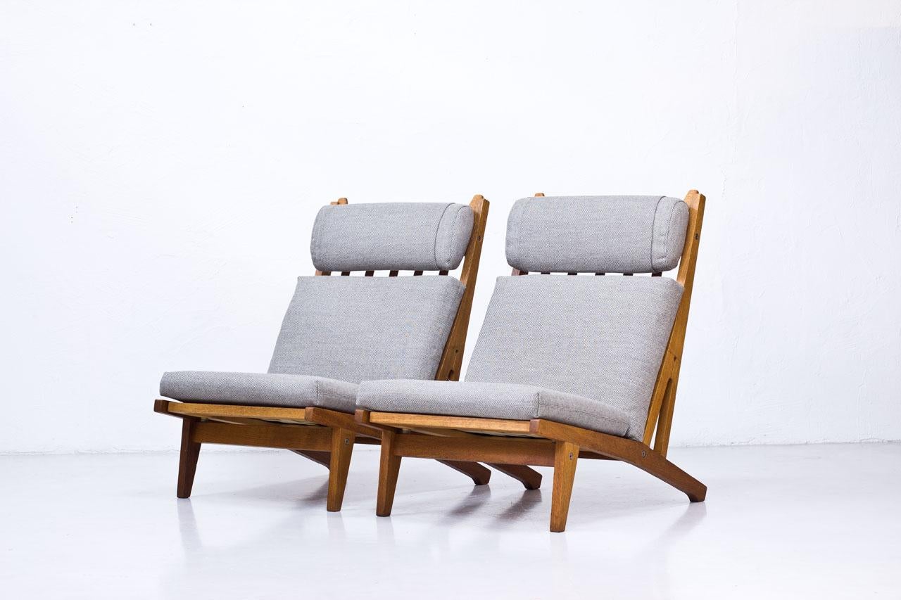 Pair of high back lounge chair model “GE- 375? designed by Hans J. Wegner. Manufactured by GETAMA in Denmark during the 1960s. Solid oak frame with loose cushions and adjustable (height) neck pillow. Cushions and neck pillow newly upholstered with