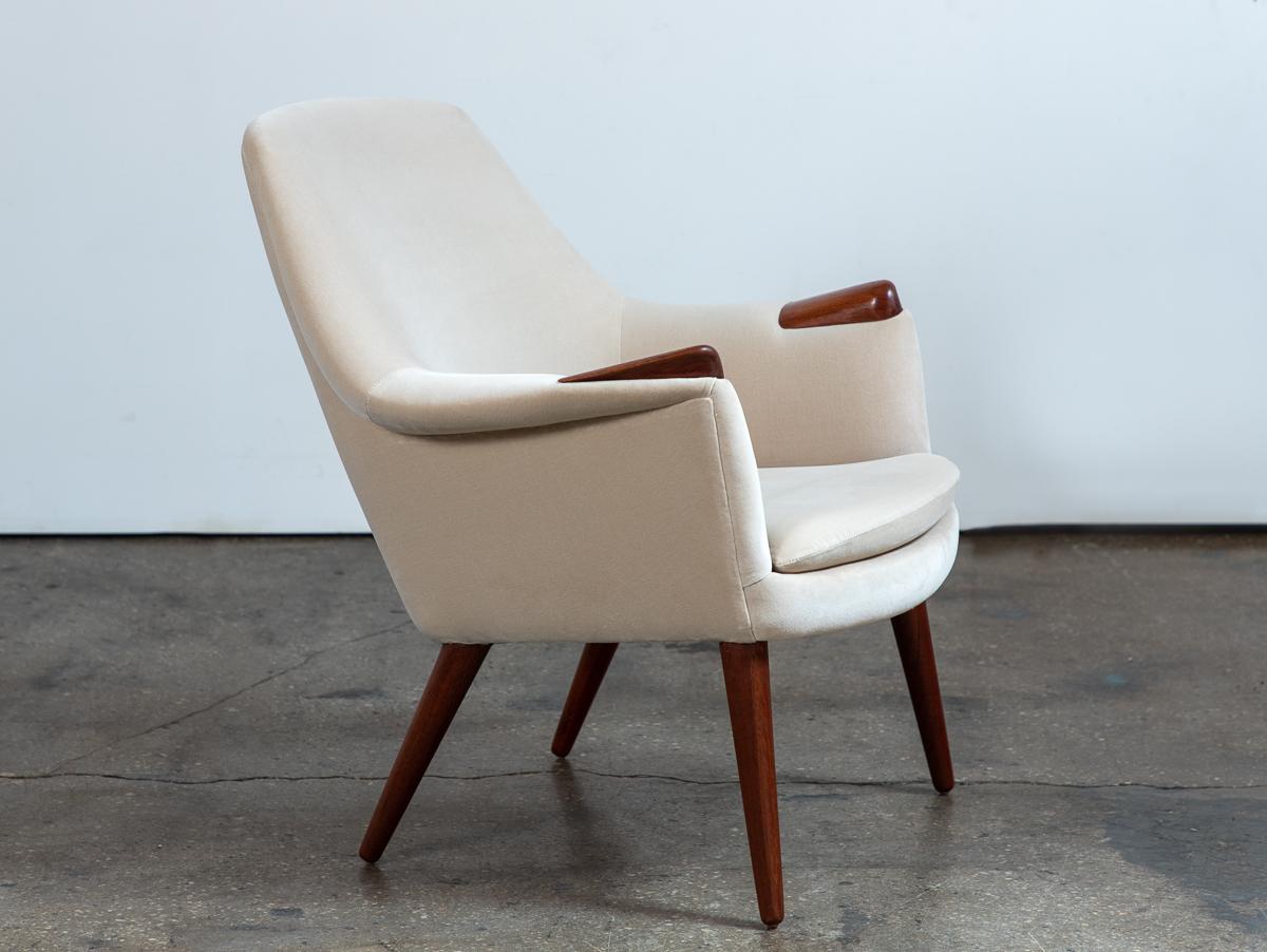 A scarce Mama Bear lounge chair, designed by Gerhard Berg for Westnofa. A classic Scandinavian modern design, featuring exquisite carved teak paws. The form is sleek and angular, but delivers an enveloping comfort. Newly reupholstered in a lovely